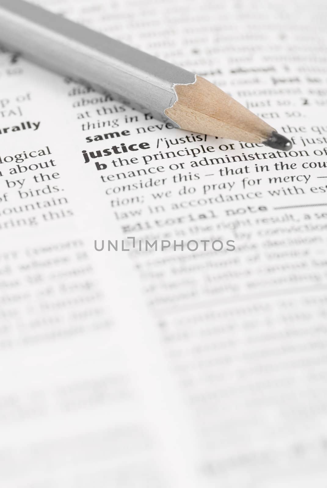 Macro image of dictionary word: Justice, and pencil.