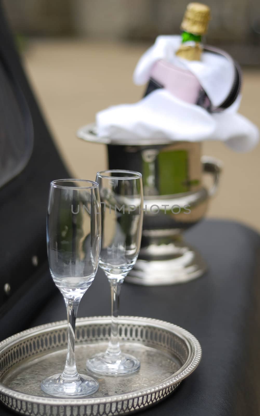 Two Champagne glasses and bottle on ice at wedding.