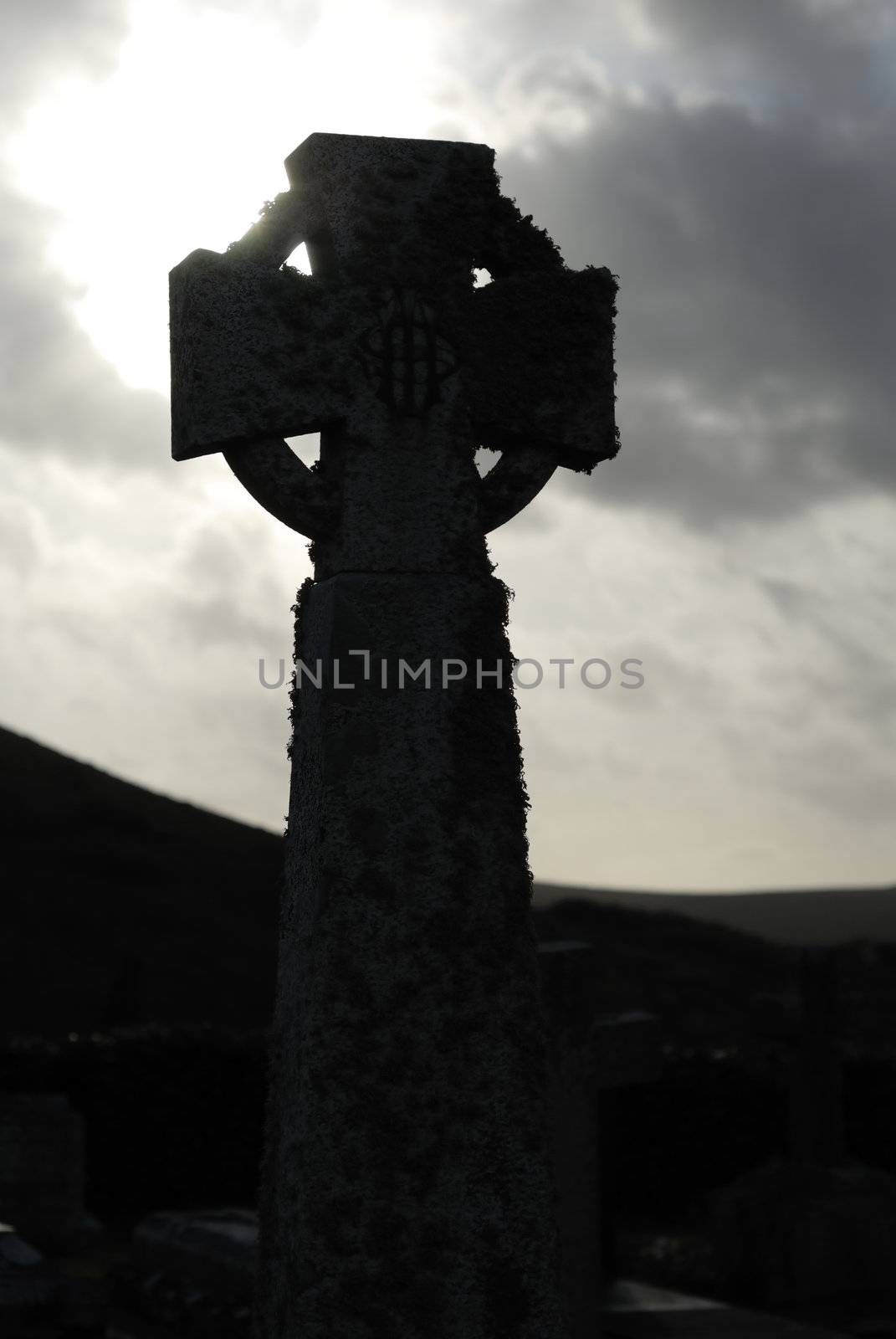 Silhouette of celtic cross in Cornish graveyard.