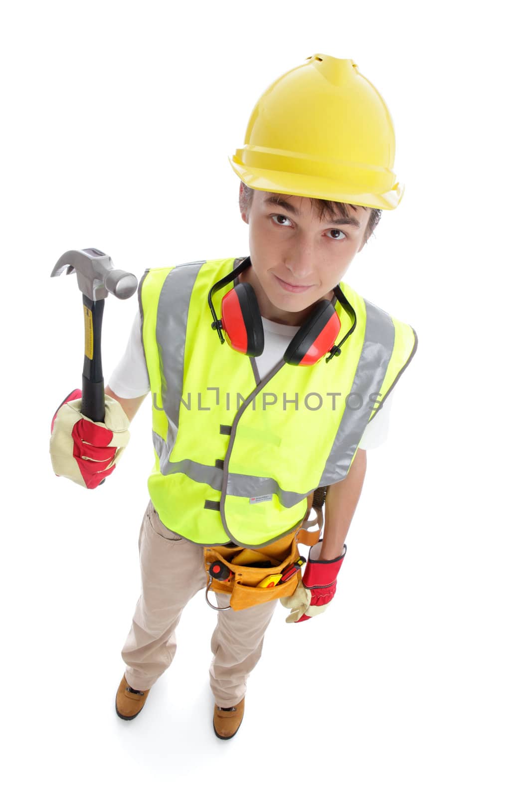 Above perspective view of a young apprentice builder wearing protective work gear and holding a hammer. White background.