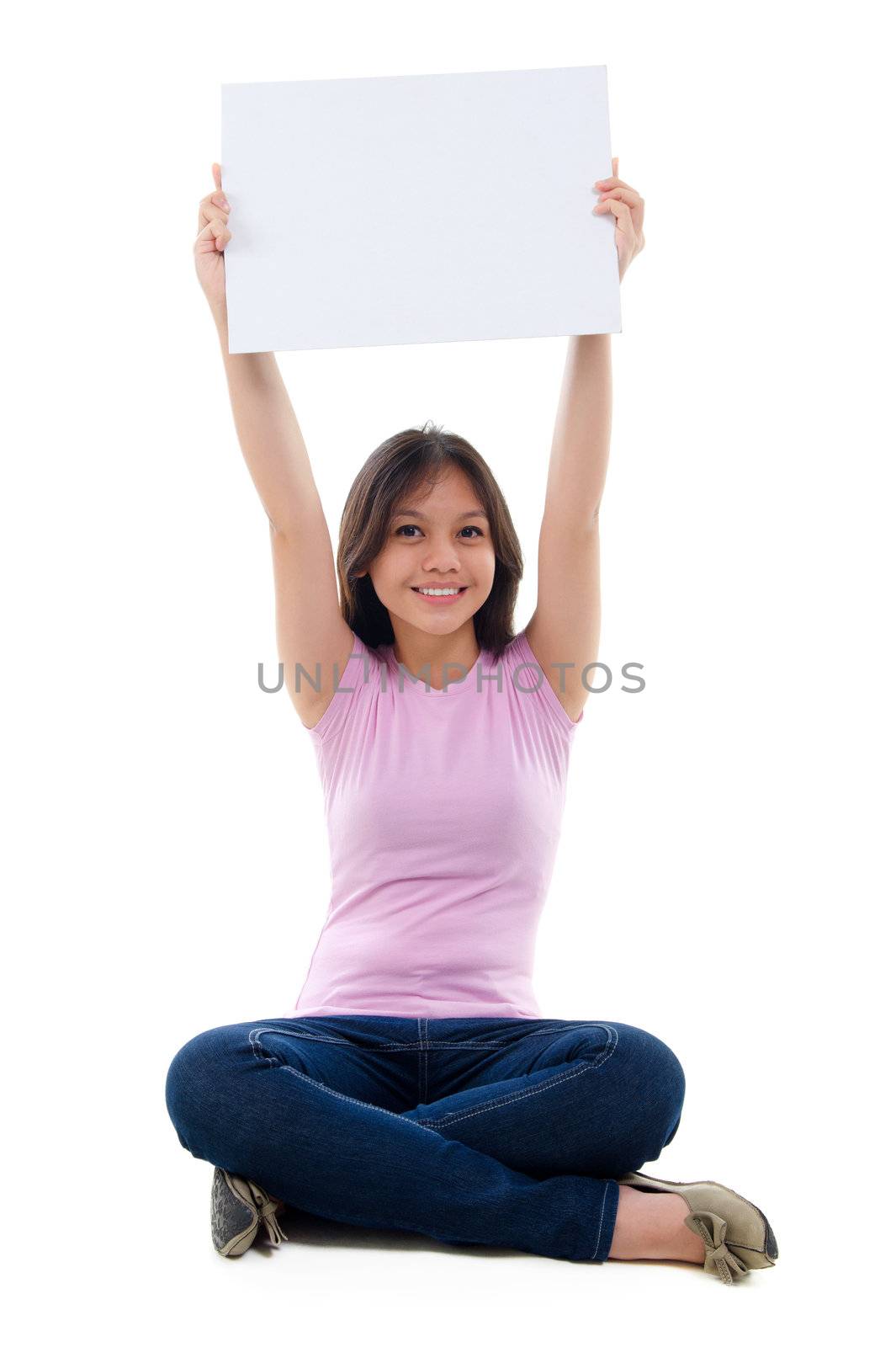 Southeast Asian young girl arms raised holding a white card board sitting over white background