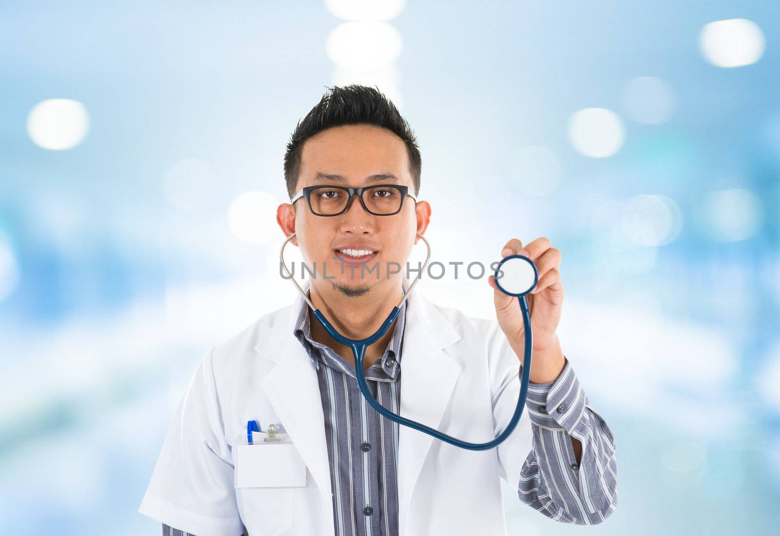 Southeast Asian medical doctor with stethoscope in hand, standing in hospital