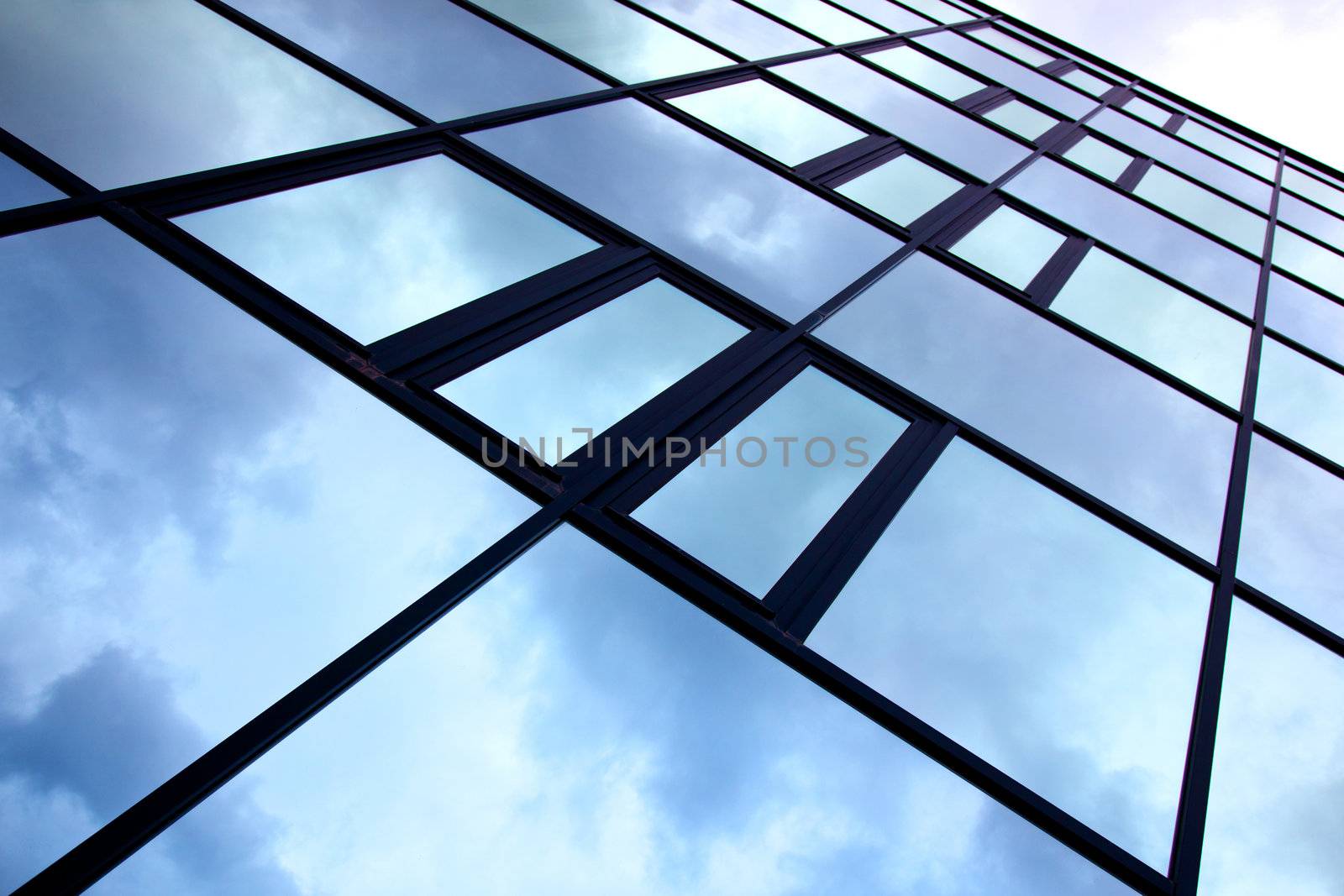 facade of office building with overcast sky reflected diagonally