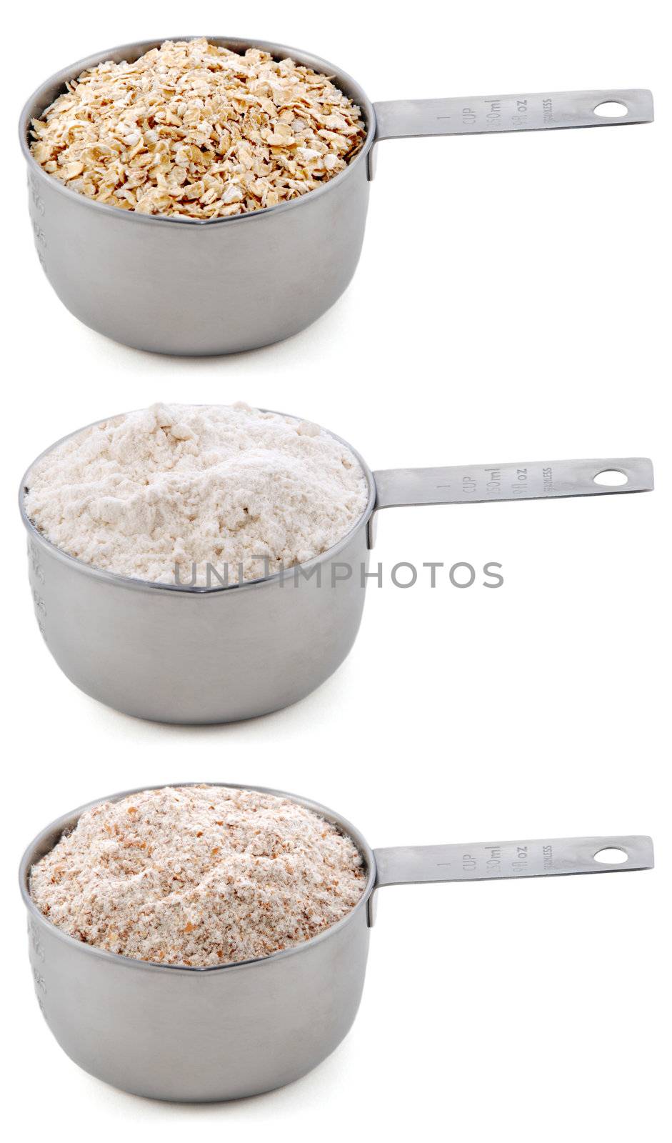 Everyday staple ingredients - rolled oats, plain or all-purpose flour and wholemeal or wheatmeal flour - in cup measures, isolated on a white background