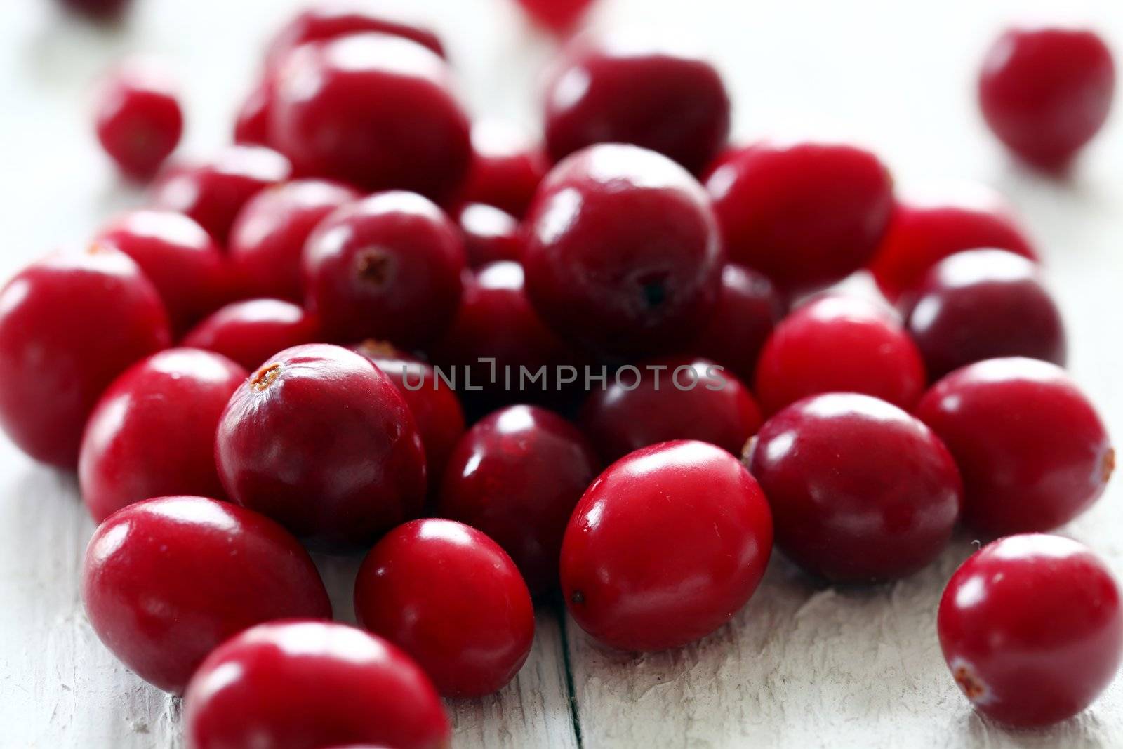 Fresh cranberries on a white wooden surface