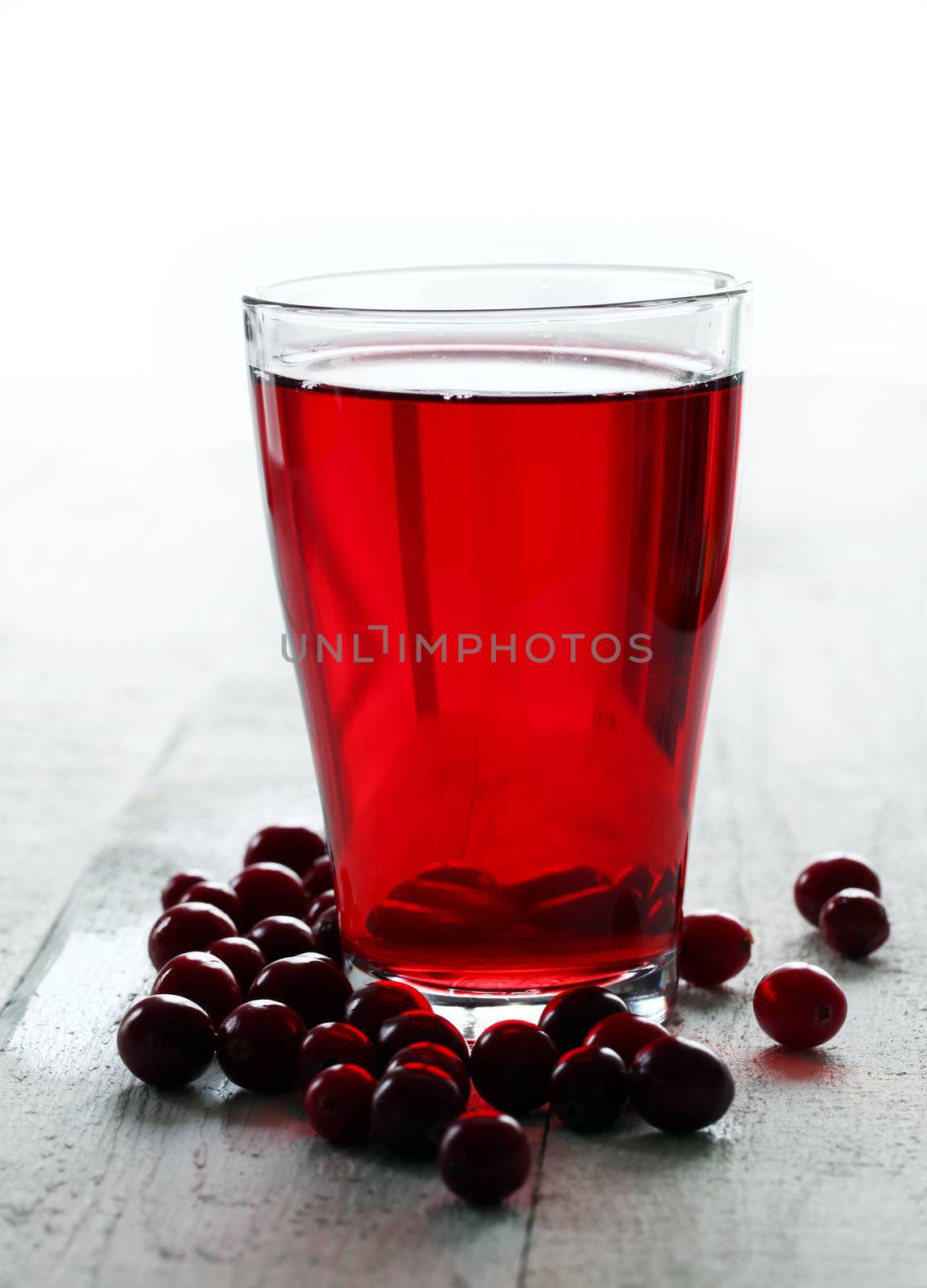 Cranberry juice and berries on a wooden surface