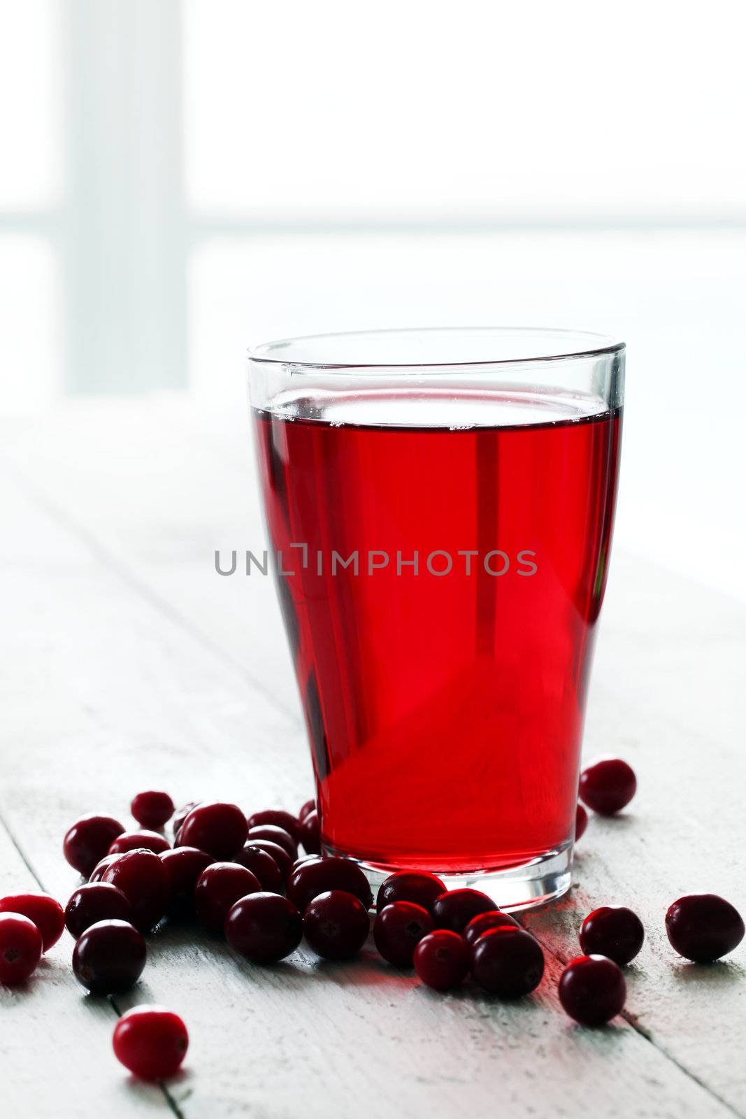 Cranberry juice and berries on a wooden surface