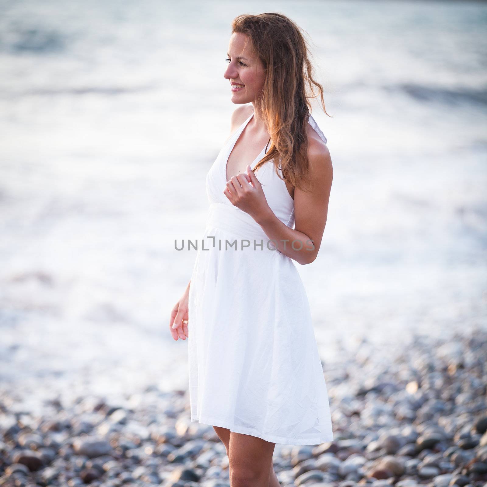 Young woman on the beach enjoying a warm summer evening by viktor_cap