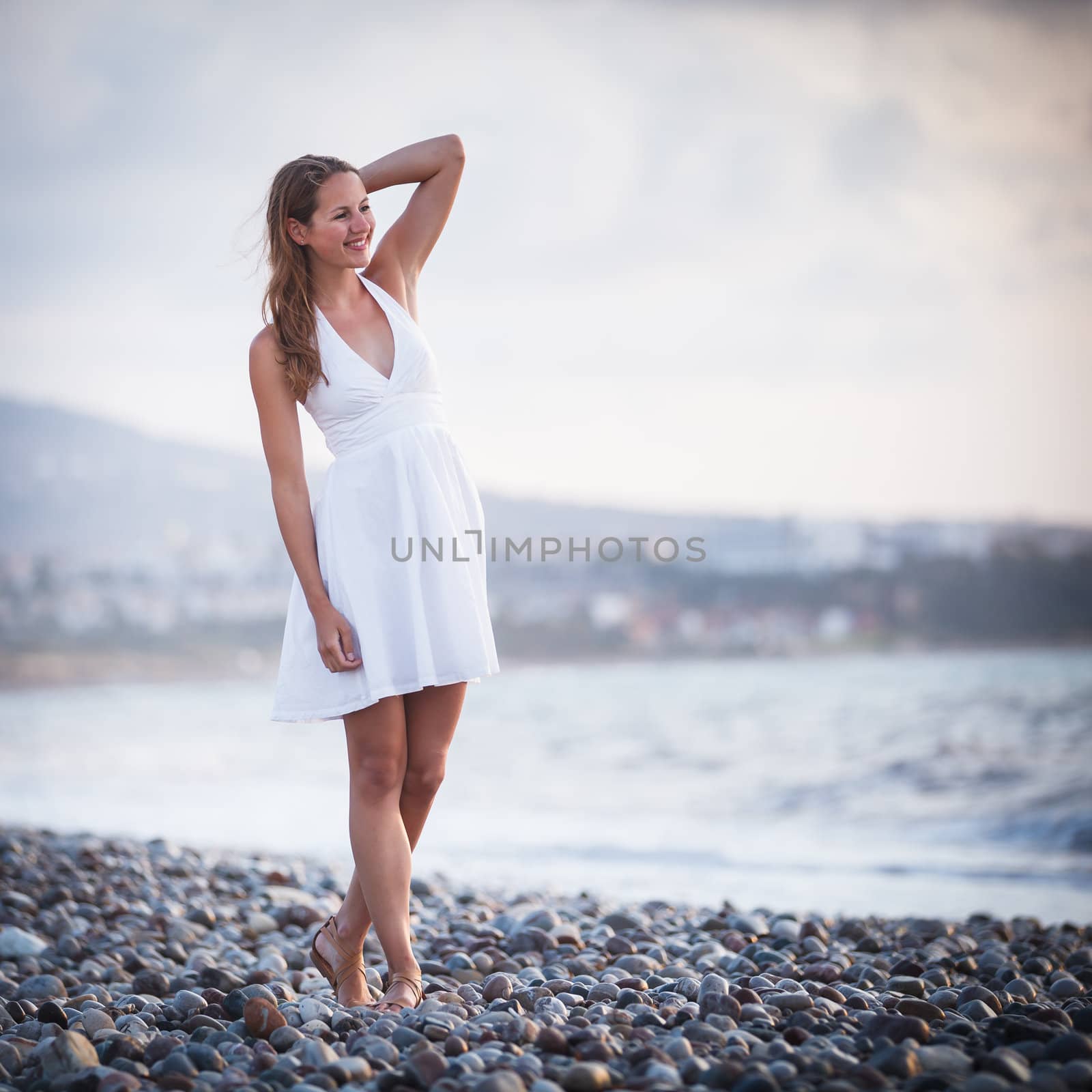 Young woman on the beach enjoying a warm summer evening