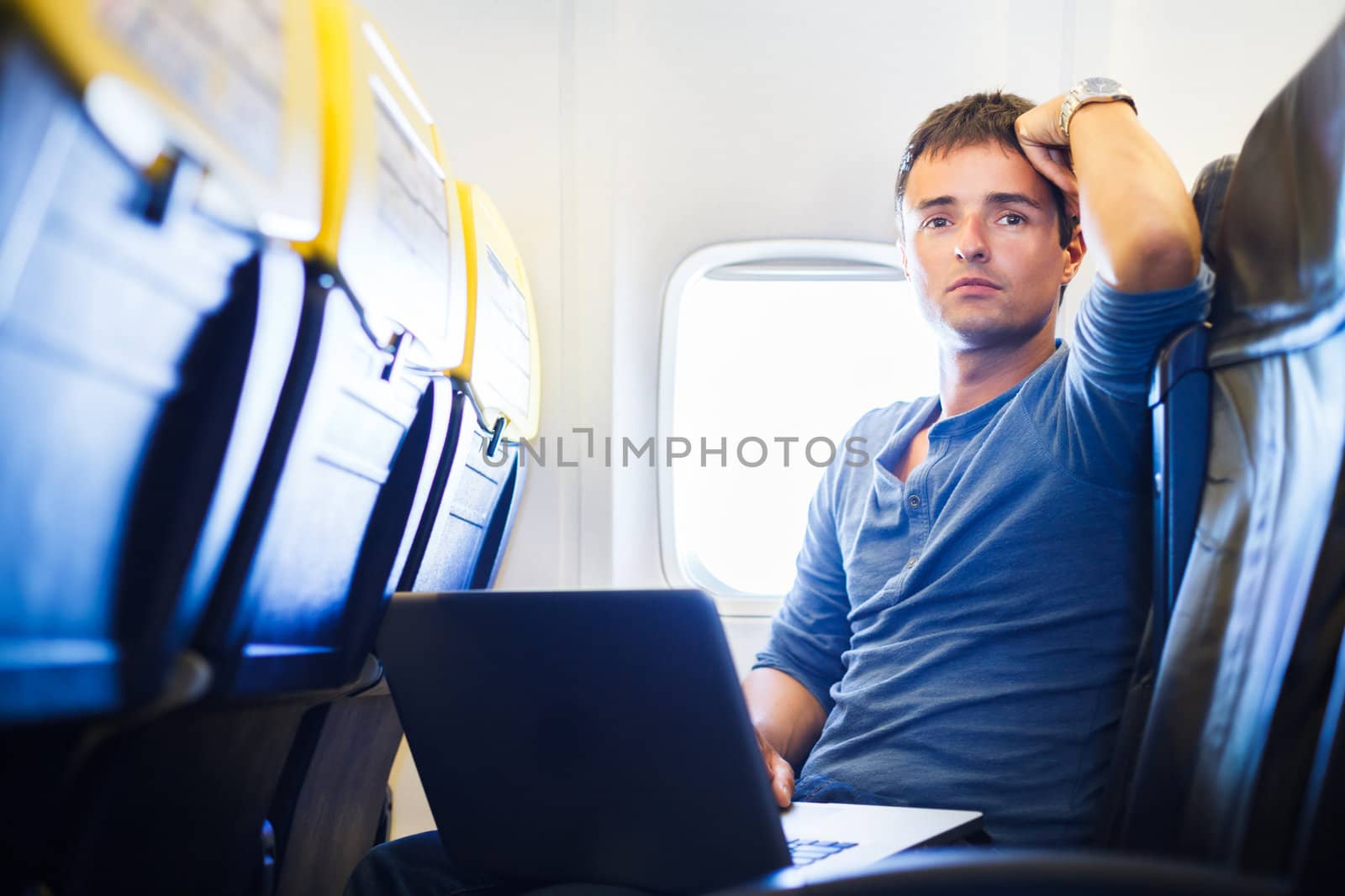 Handsome young man daydreaming while working on his laptop by viktor_cap