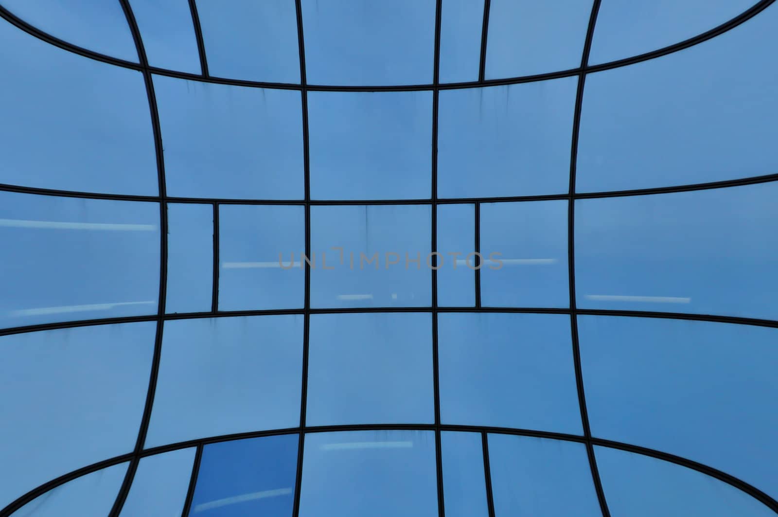 Distorted glass facade of modern building. Abstract architectural detail.