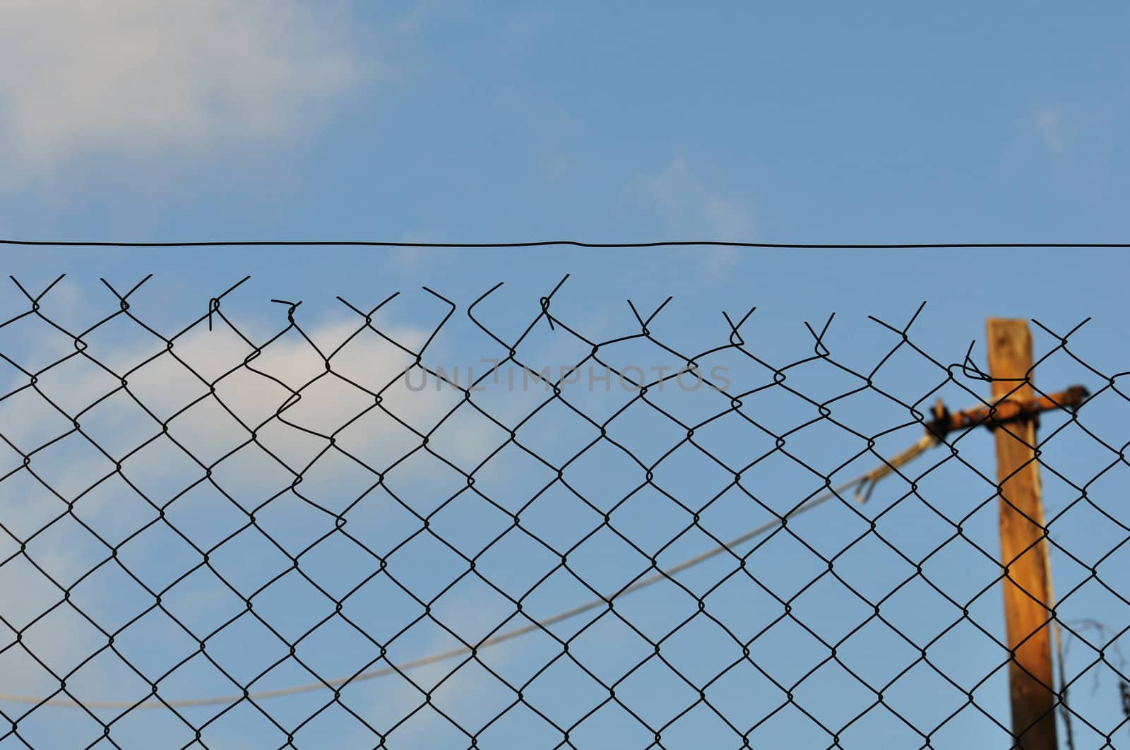 Chain link fence and blue sky urban background.