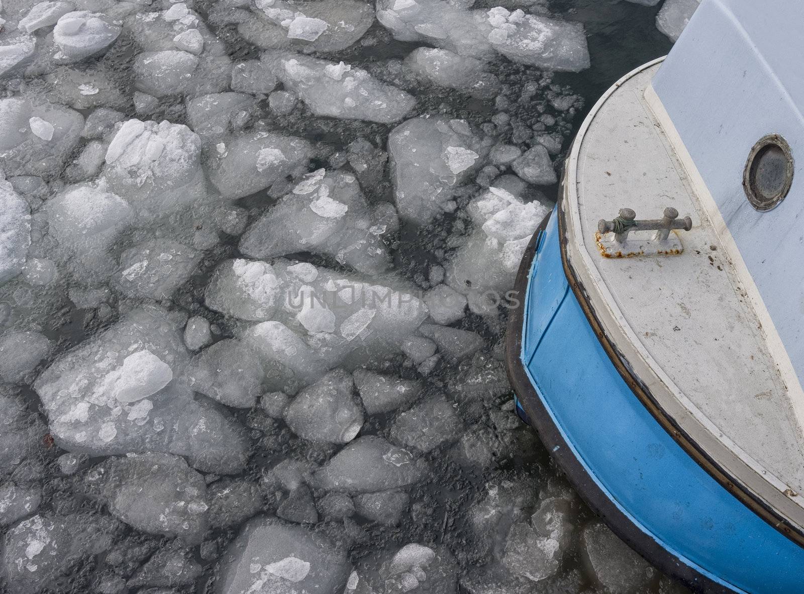 Tiny fishing boat caught by the ice in the harbor of Nyborg - Denmark.