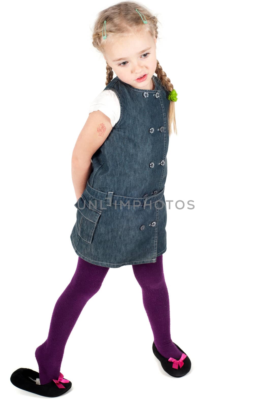 Studio portrait of little cute girl in denim dress