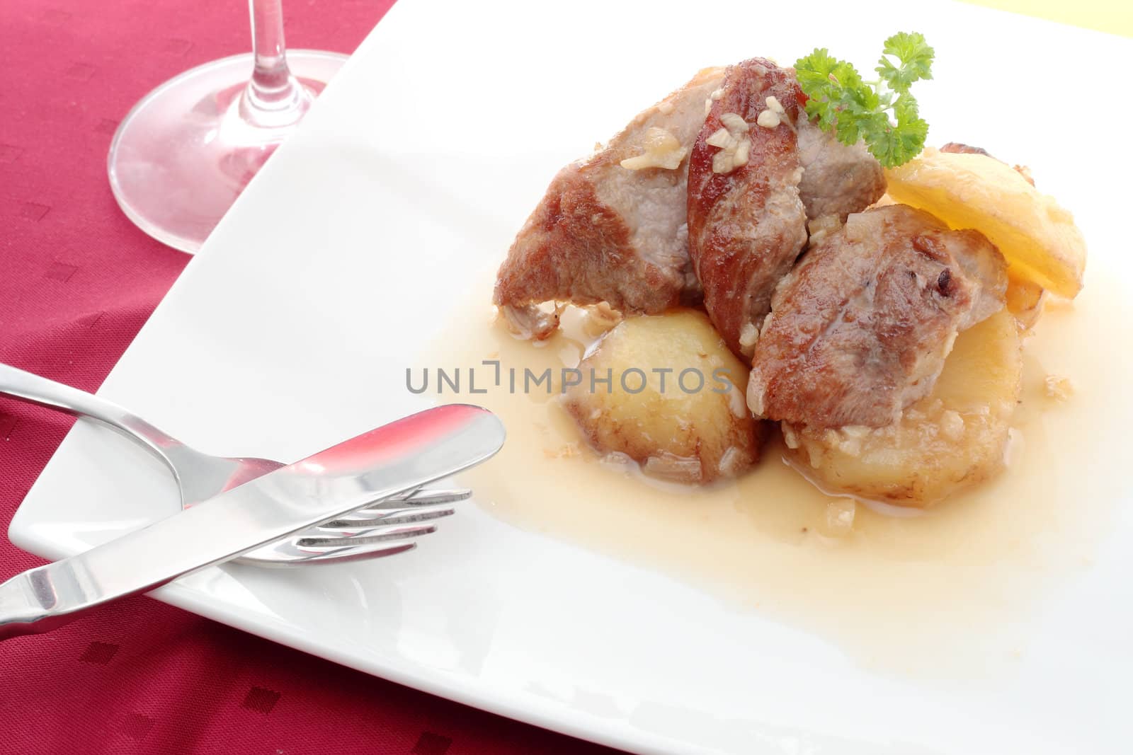 dish of chopped pork sirloin accompanied by baking potatoes and wine sauce garlic and onion