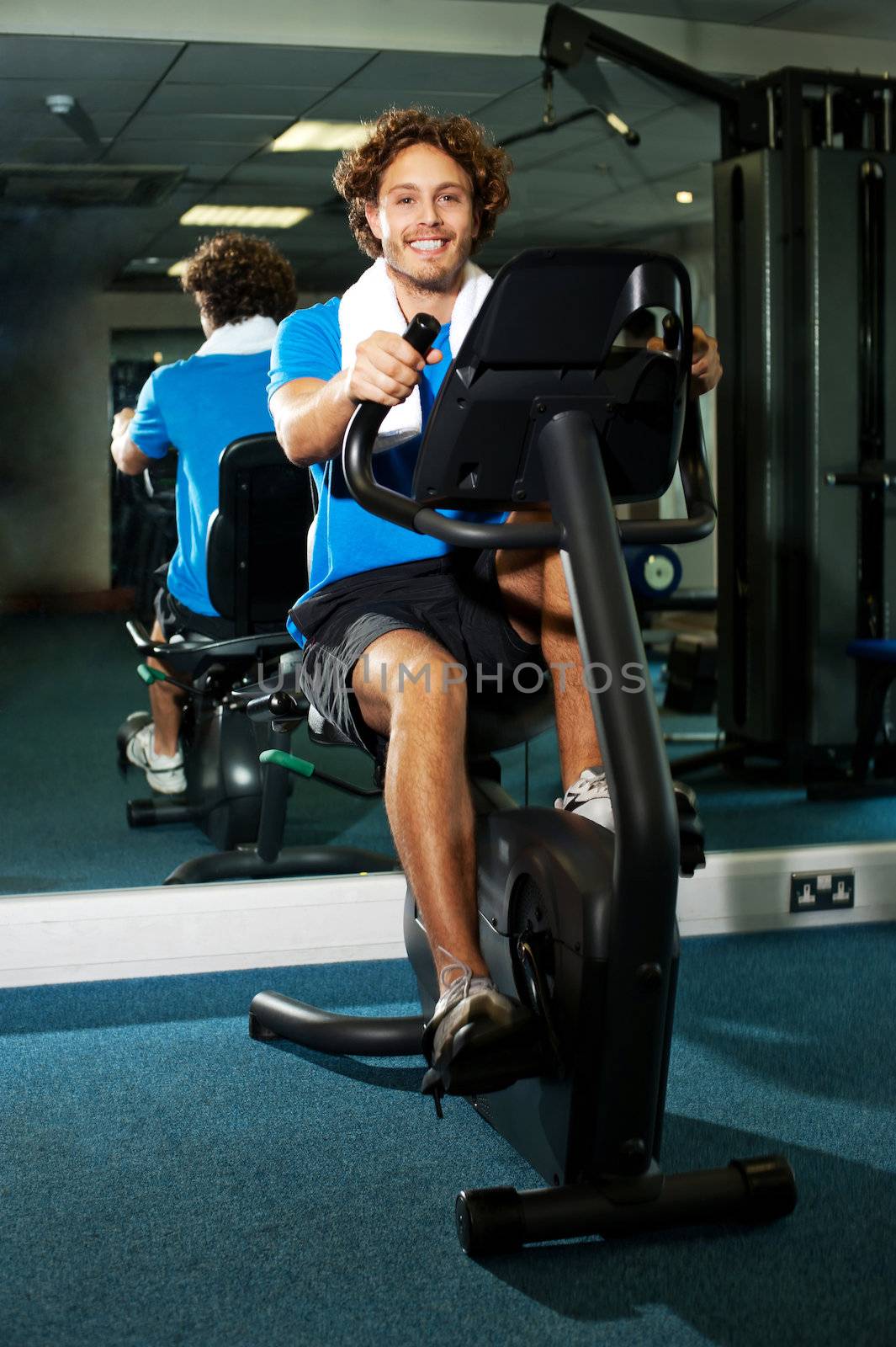 Smart guy working out in the exercise bike, cycling fast