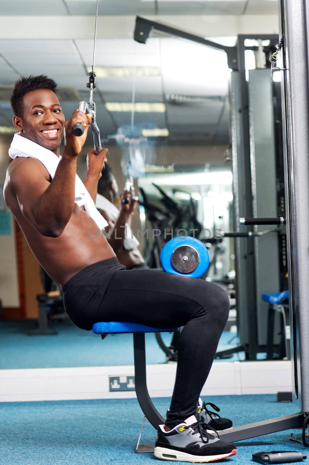 Fit african trainer working out in multi gym. Keeping fit and healthy