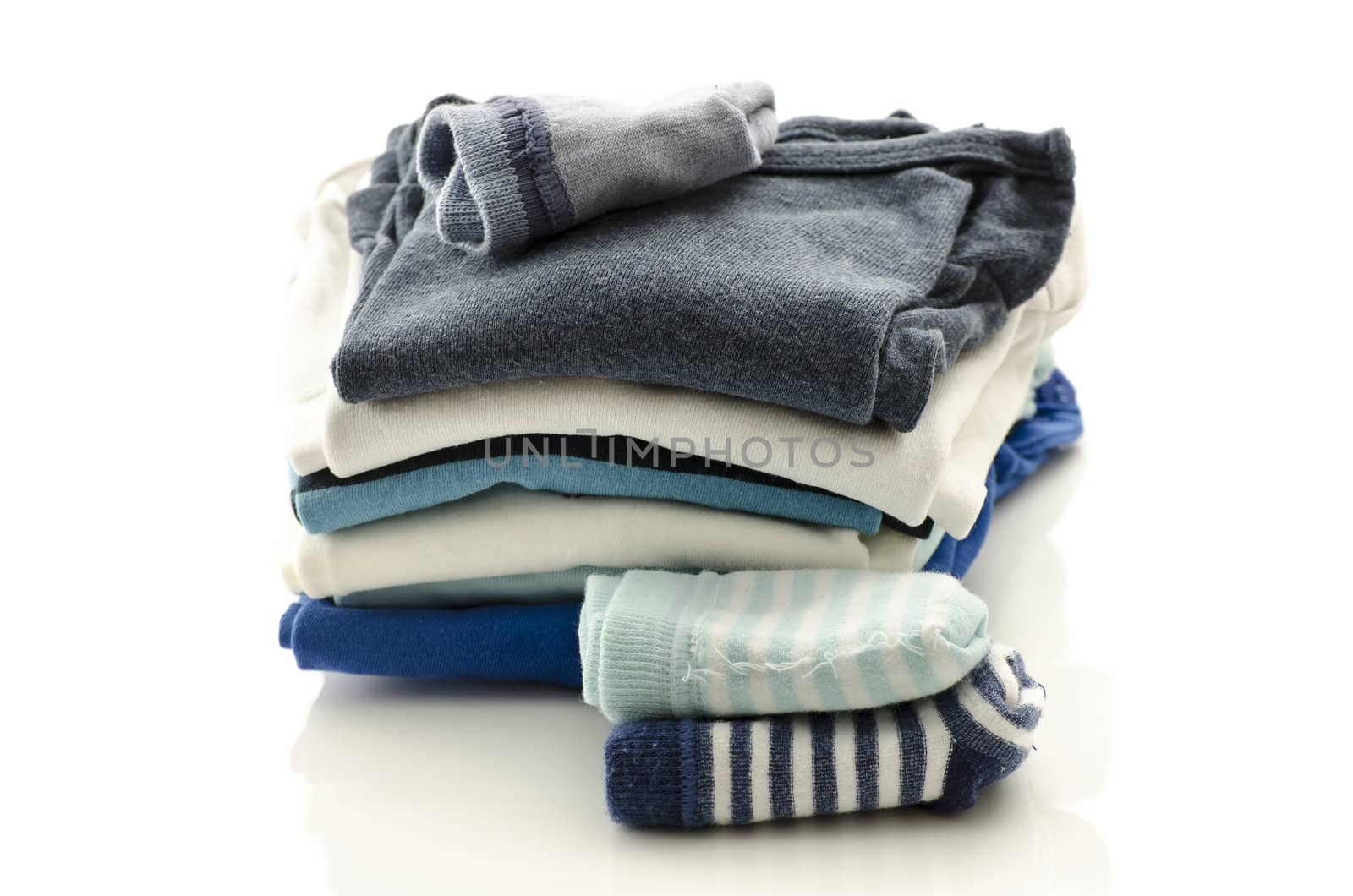 A stack of baby clothes with socks isolated on a white background.