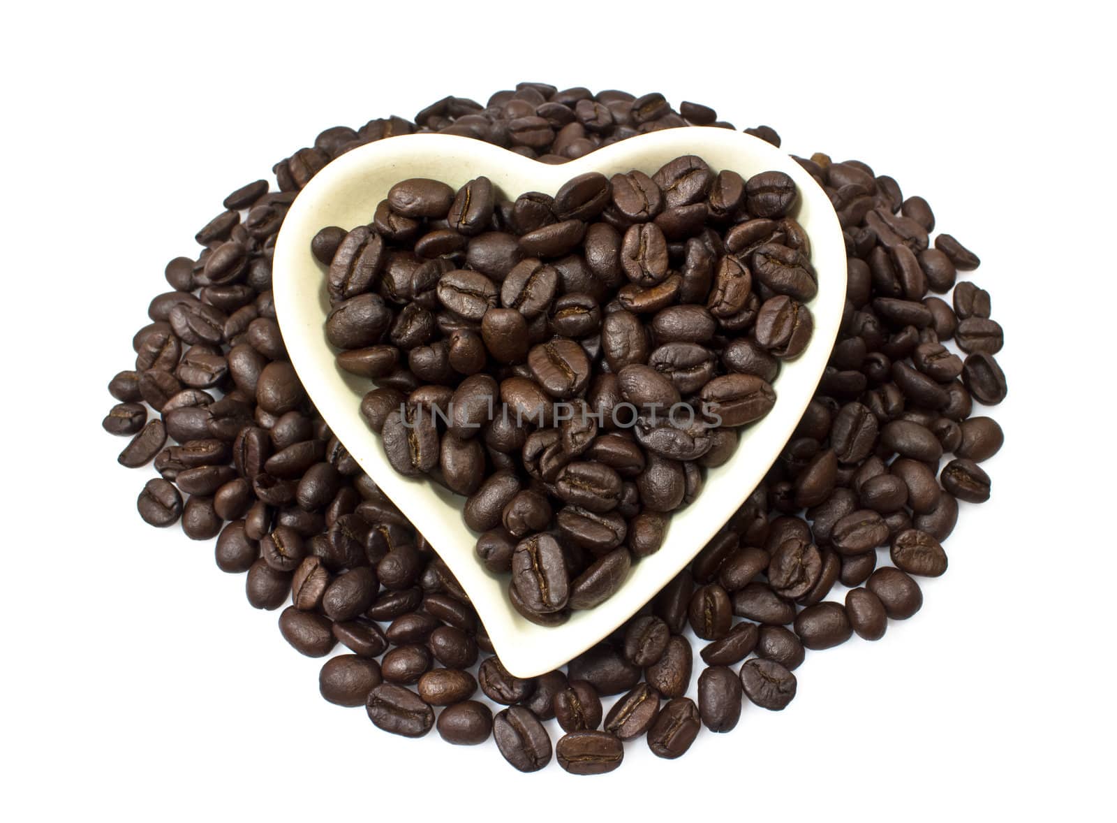 Black coffee beans in heart shaped bowl.