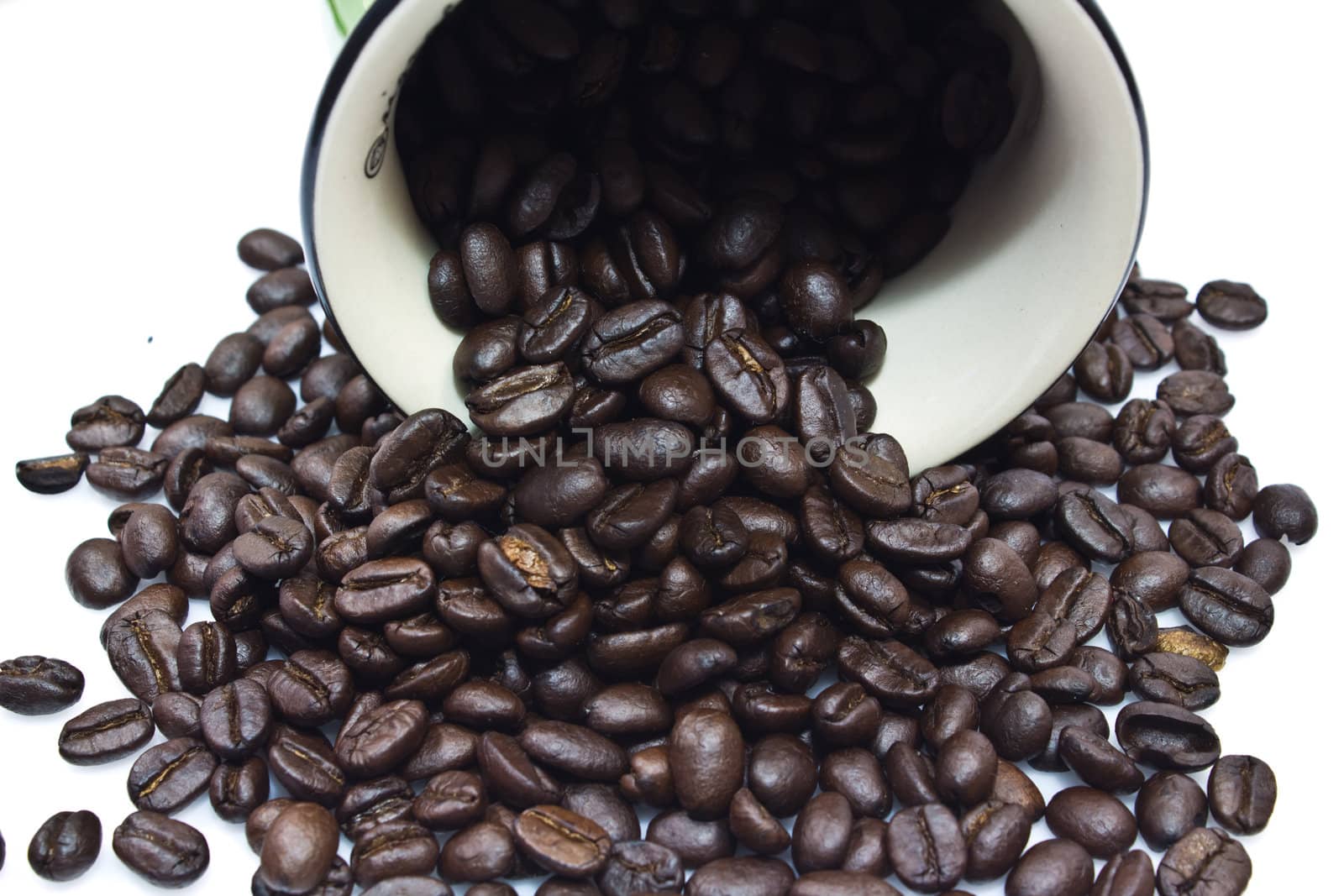 Black coffee beans in bowl on white background