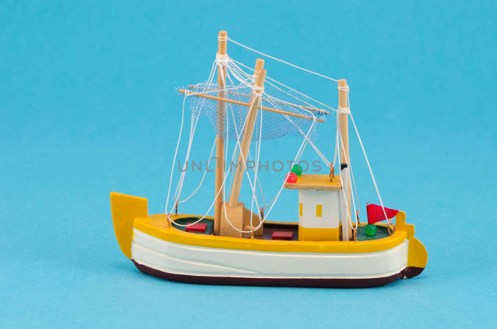 wooden handmade object boat ship with sail model decoration on blue background.