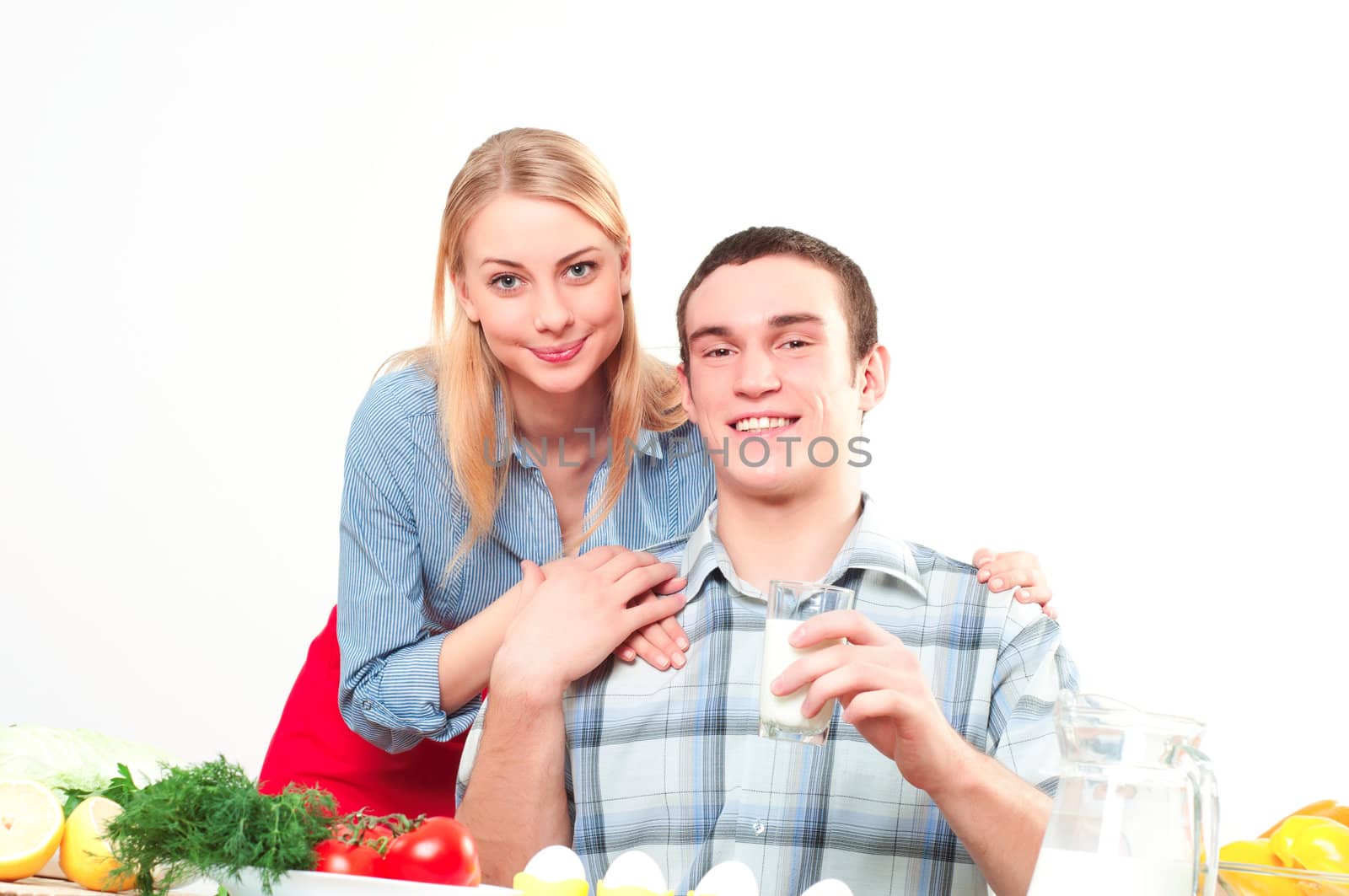 wife embraces the husband, he holds a glass of milk