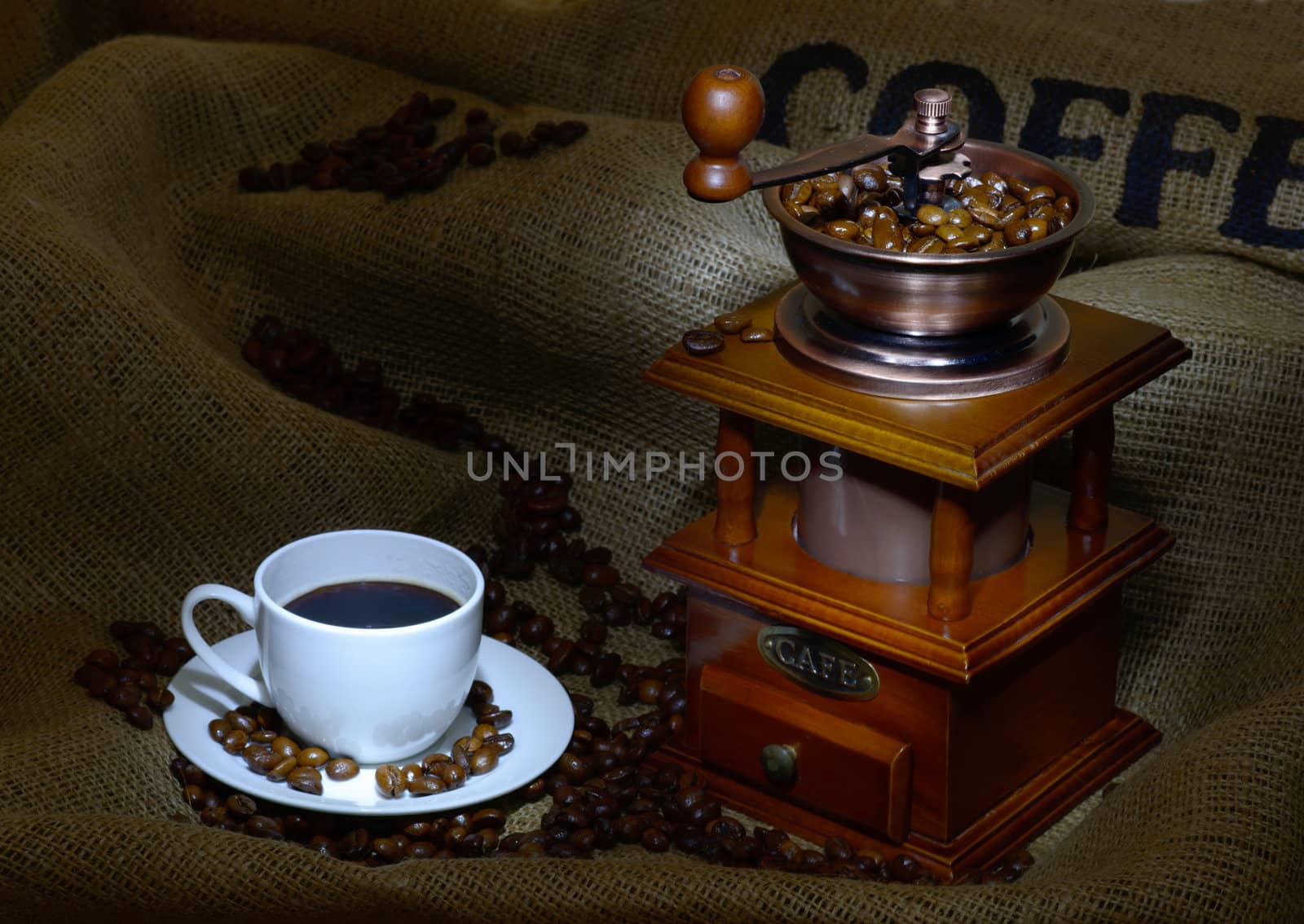 Coffee Mill with beans, cup and burlap. still life