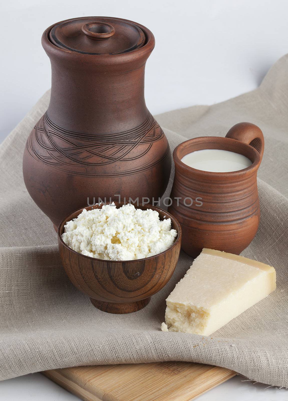 Jug, milk in mug, curds and cheese on the tablecloth