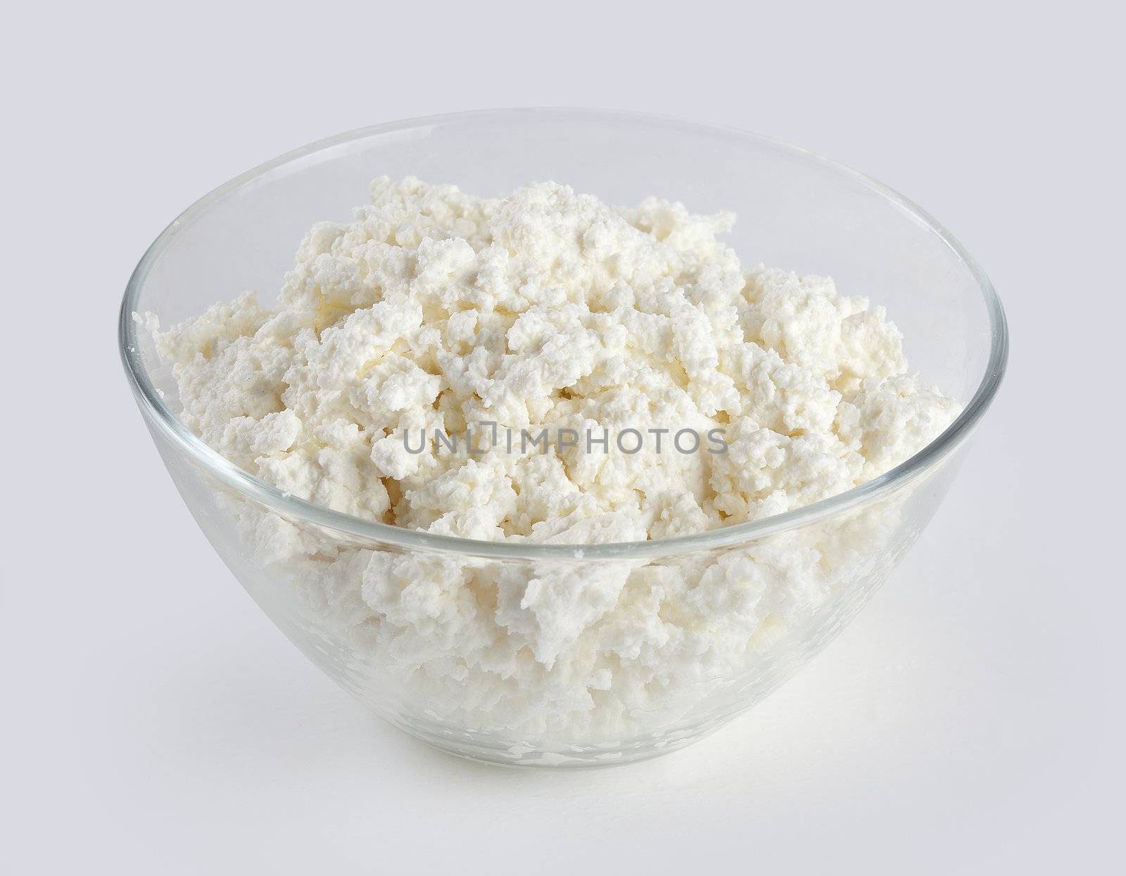 Cottage cheese in the transparent glass bowl