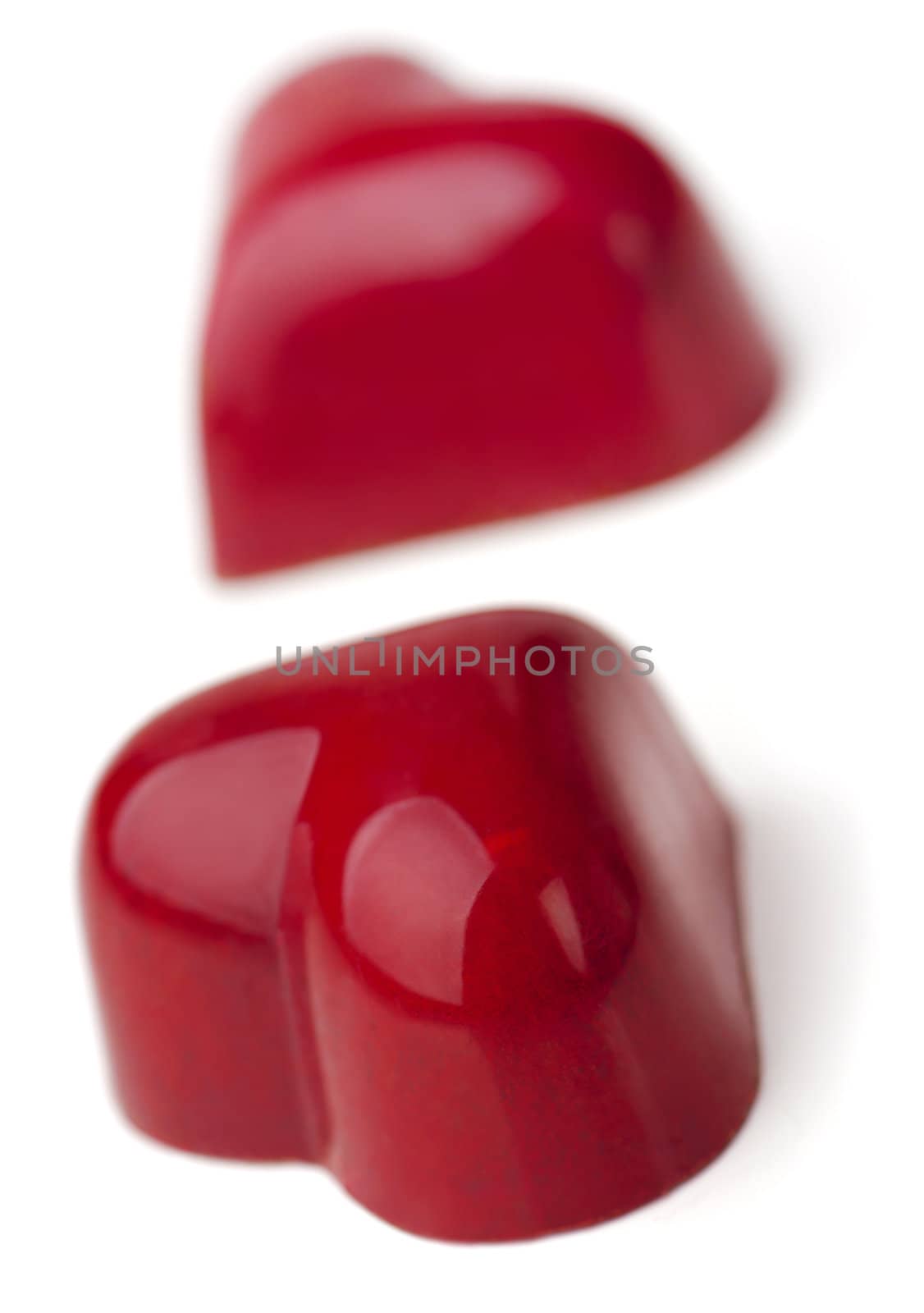 Heart shaped Chocolate Pralines coated with burgundy glaze.  White background.