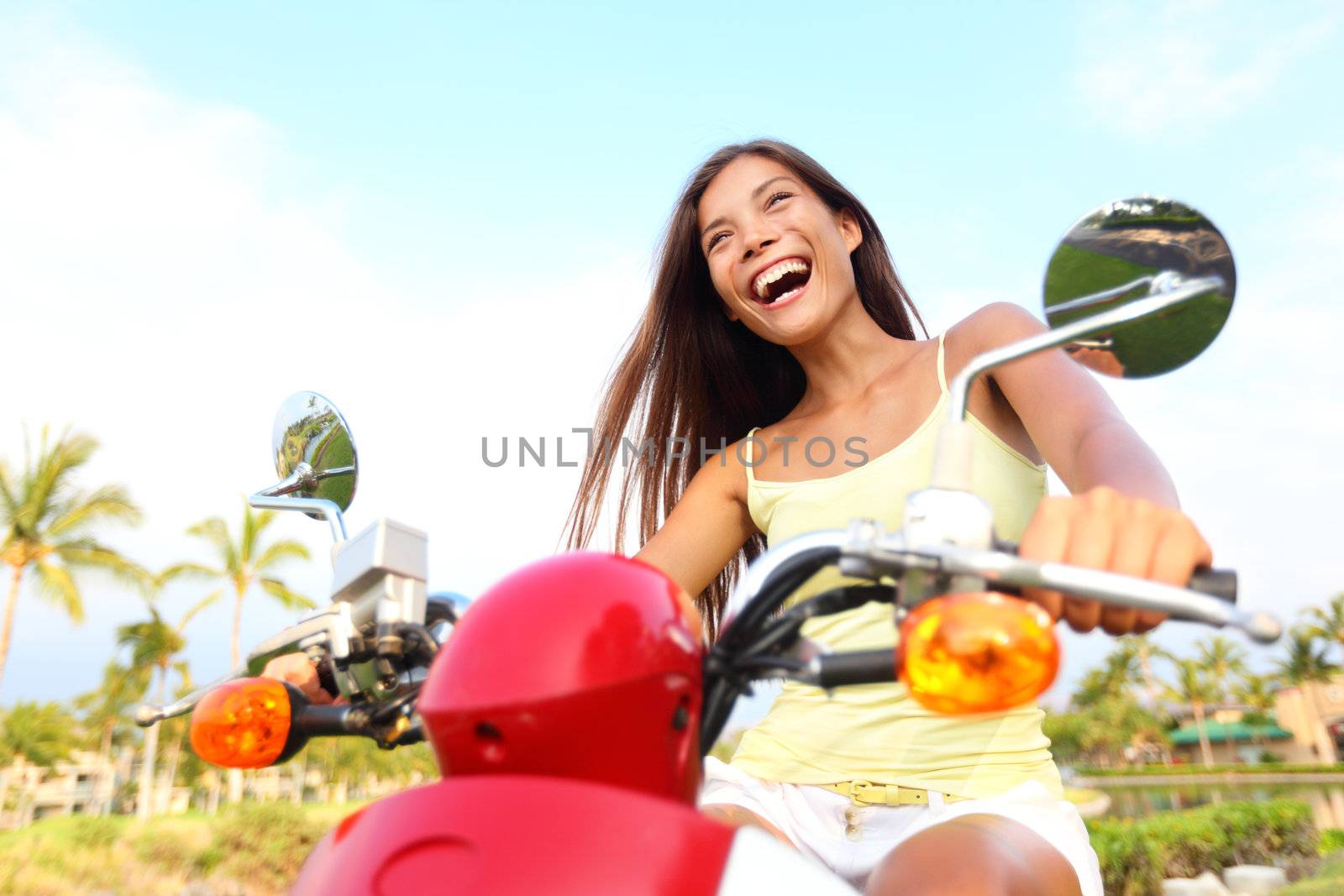 Happy free asian woman on scooter. Freedom concept with excited joyful asian woman driving scooter outdoor on summer vacation holidays.