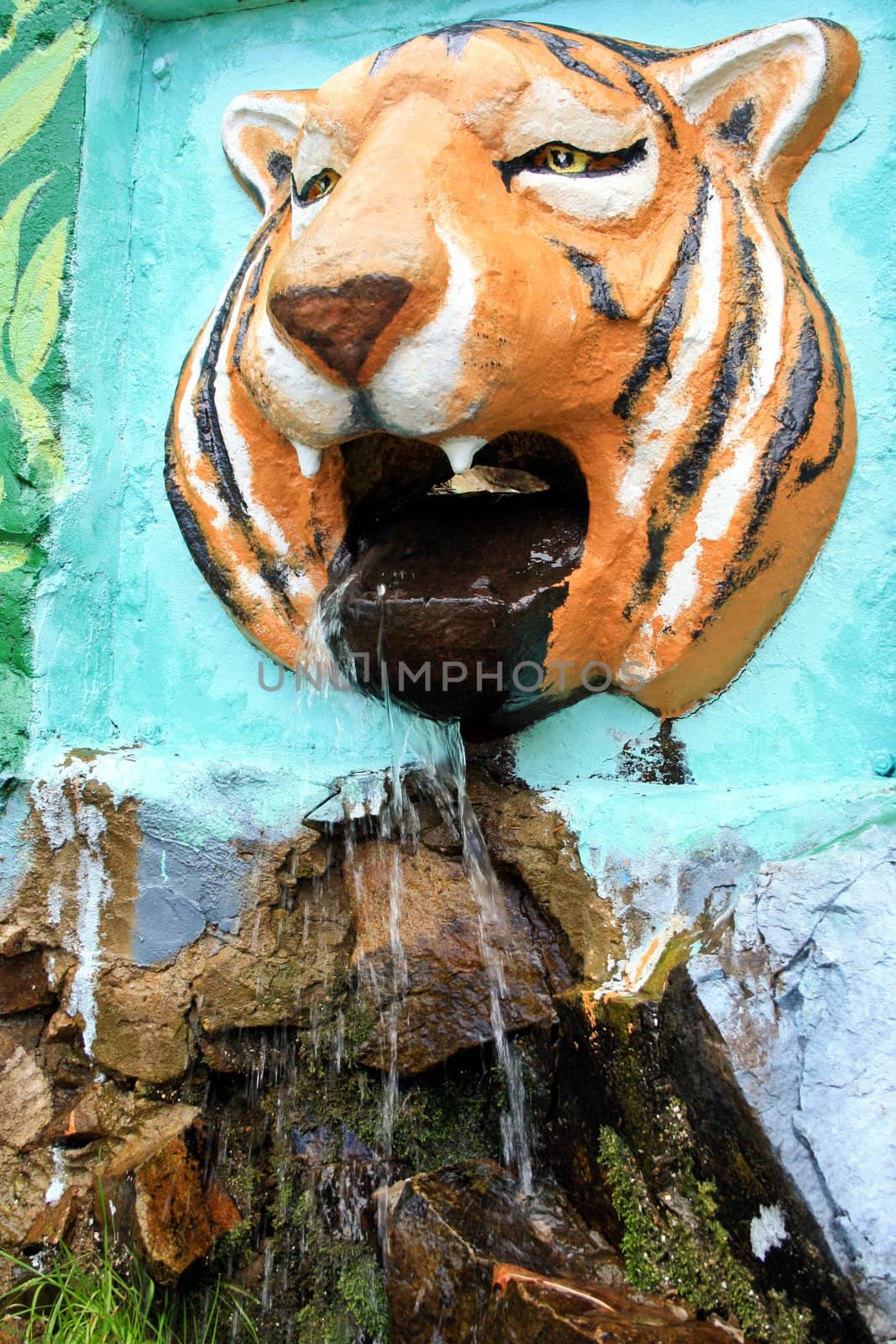 Water flows from a mouth of a stone tiger