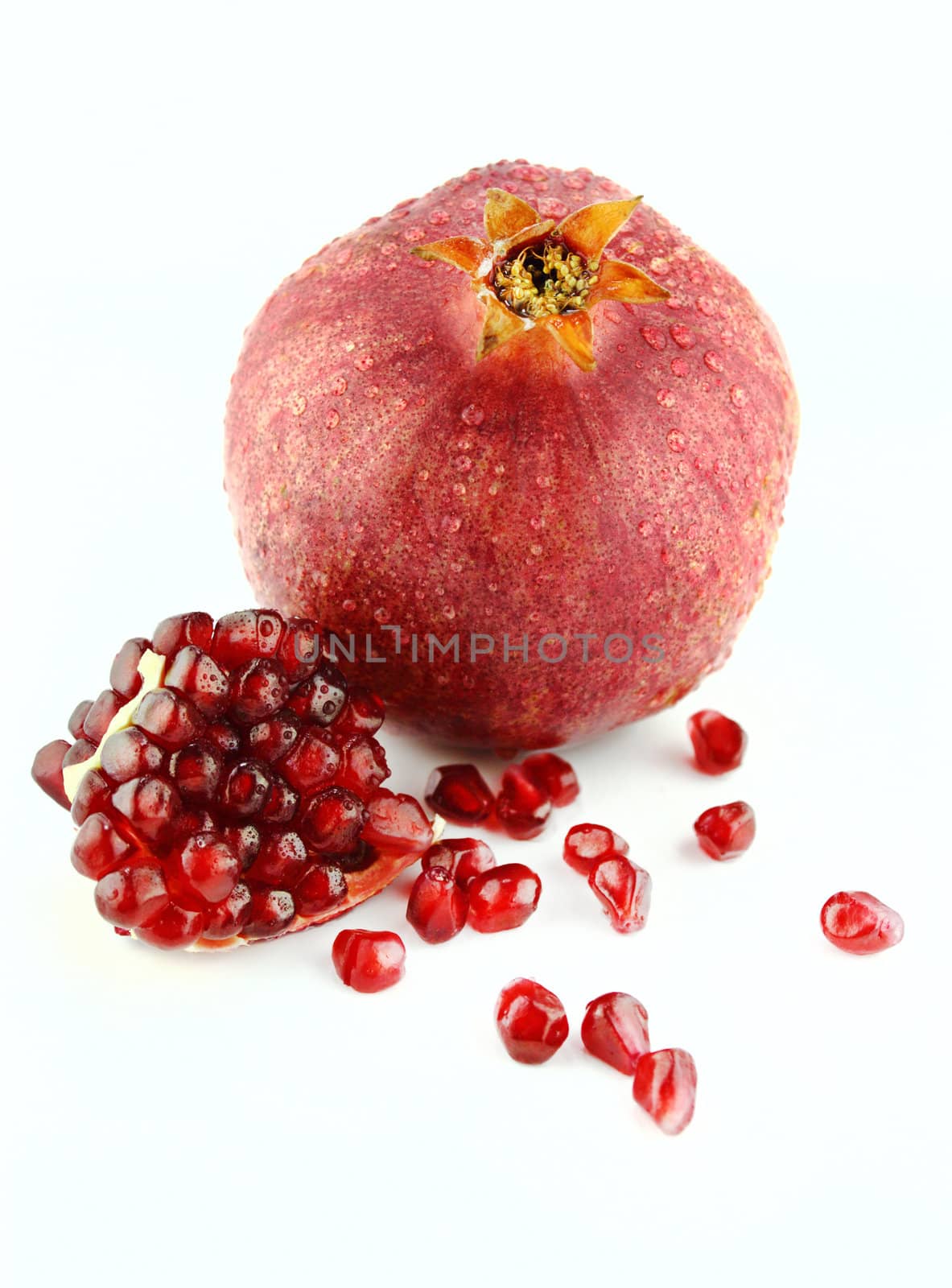 Ripe pomegranate fruit and part isolated on white background .