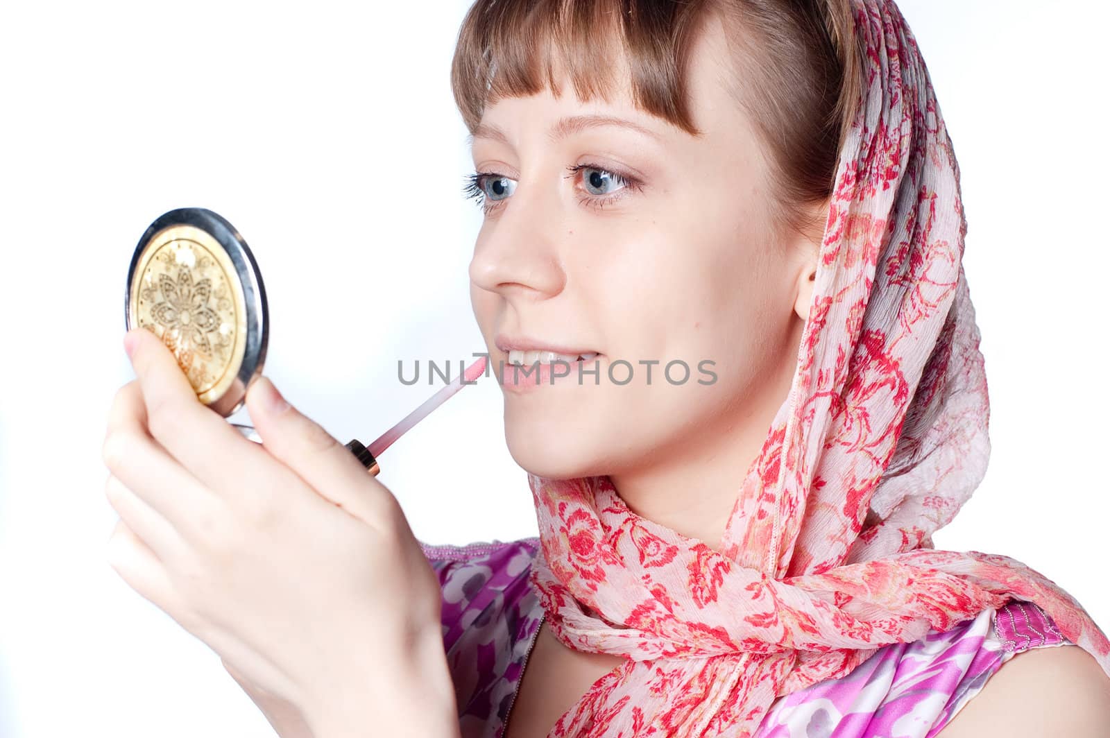 a young girl wearing a scarf does makeup for lips