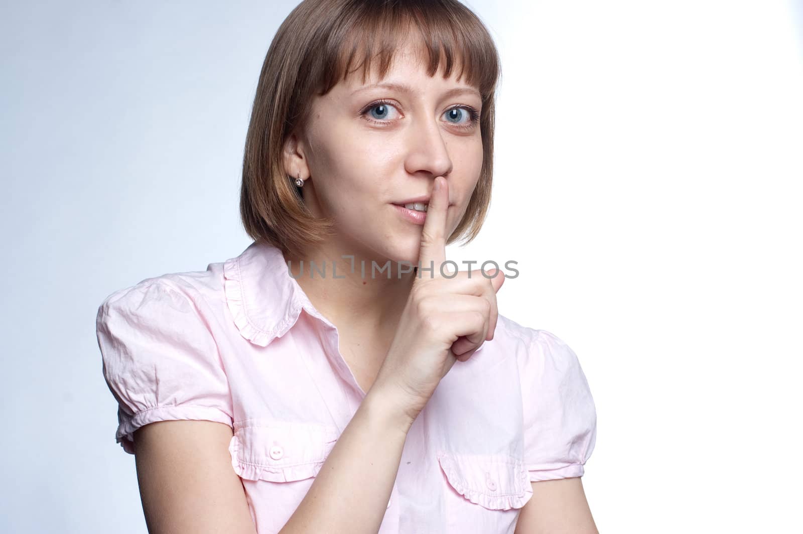 girl holds a finger at the lips