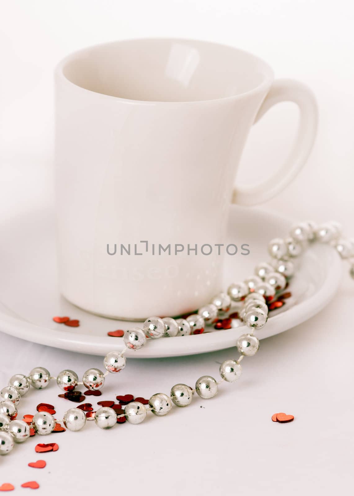 Coffee cup on a white background with red glitter hearts