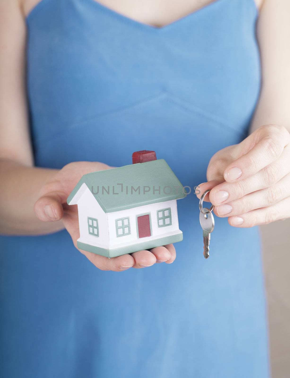 Woman in blue dress offers house toy and keys