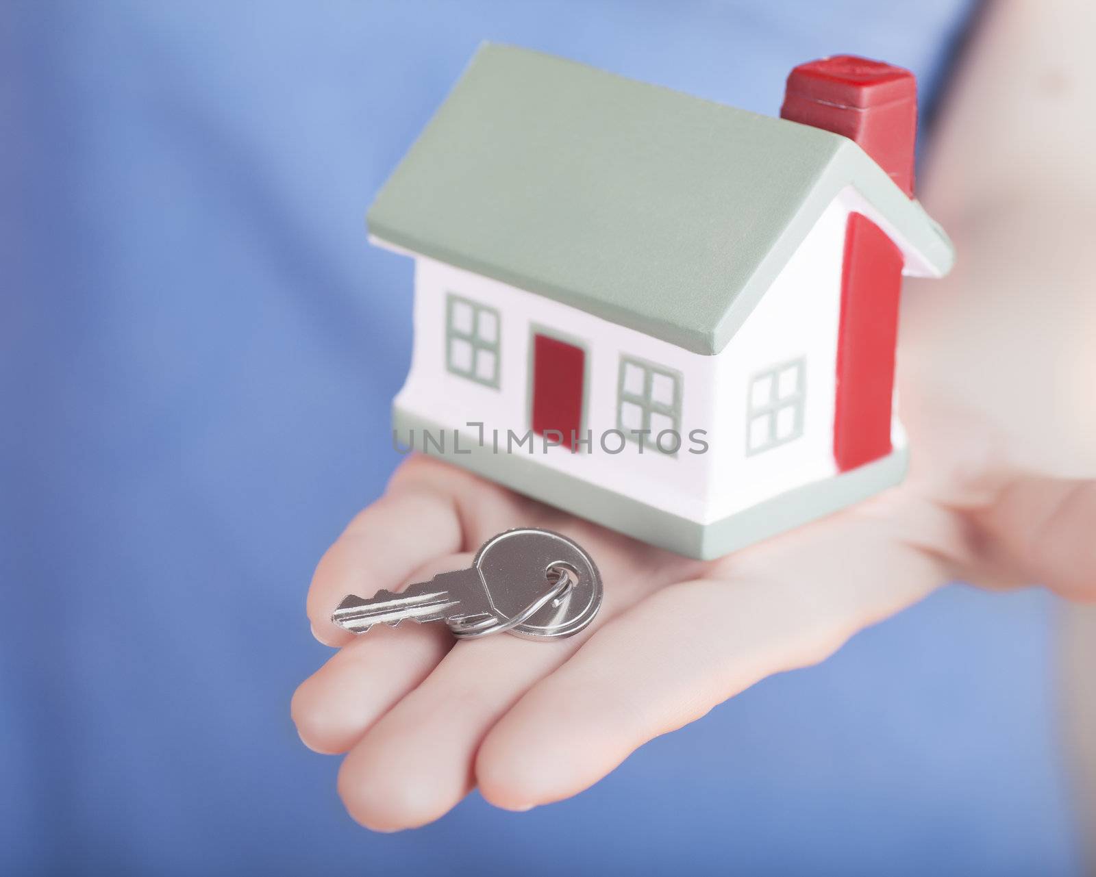 Little house toy and key in woman's hand