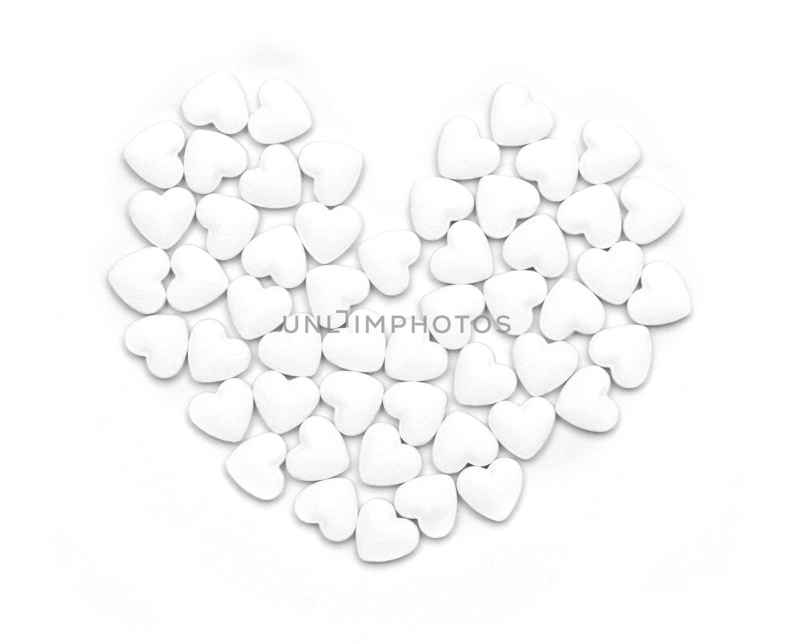 White pills form heart shape isolated on grey background