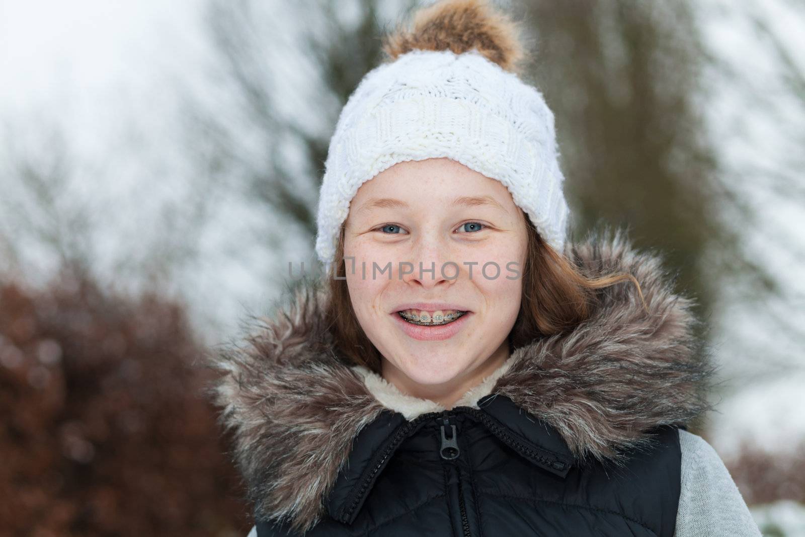 Outdoor portrait of a smiling teenager girl in winter clothing