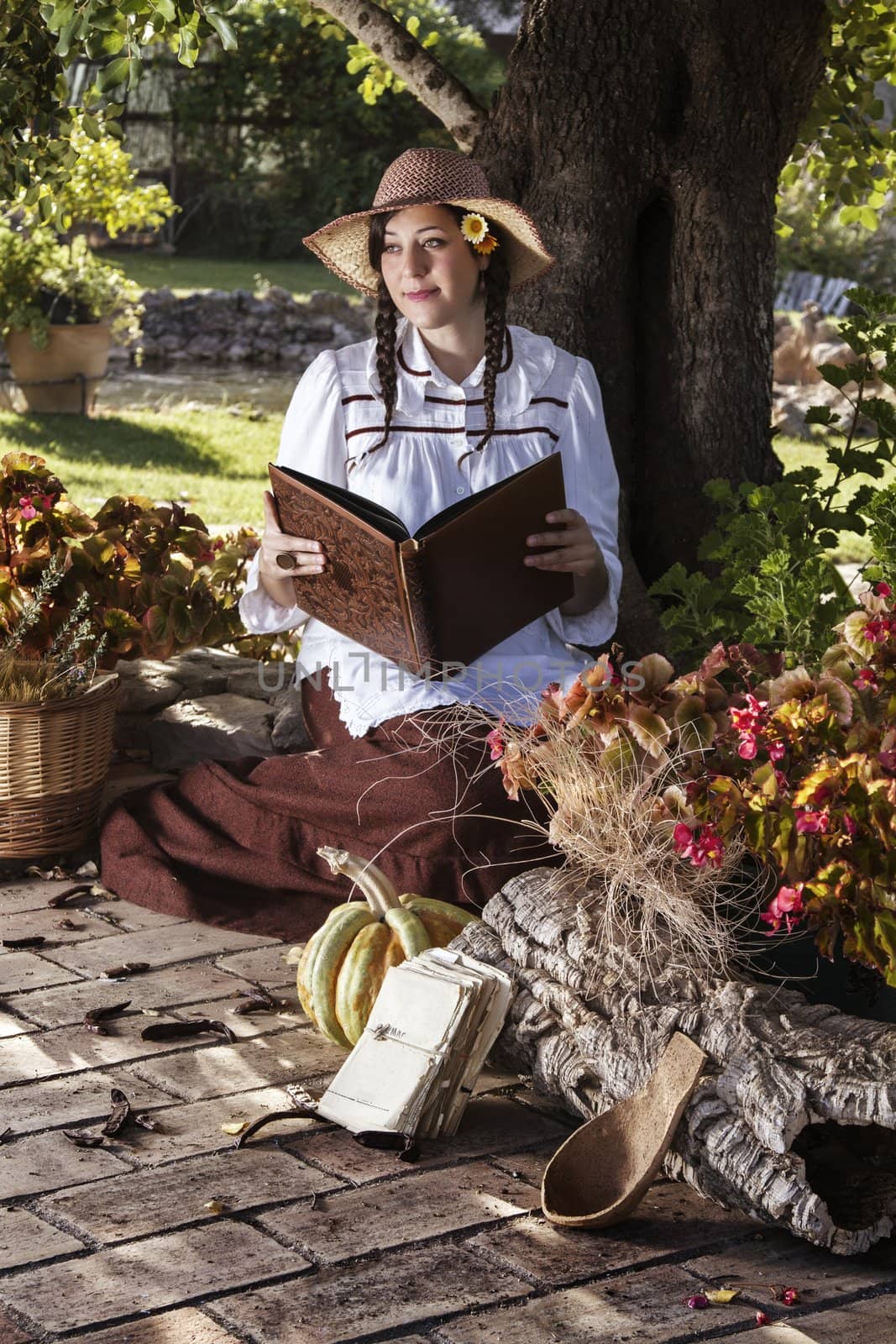 View of a beautiful girl in a classic dress reading a story book.