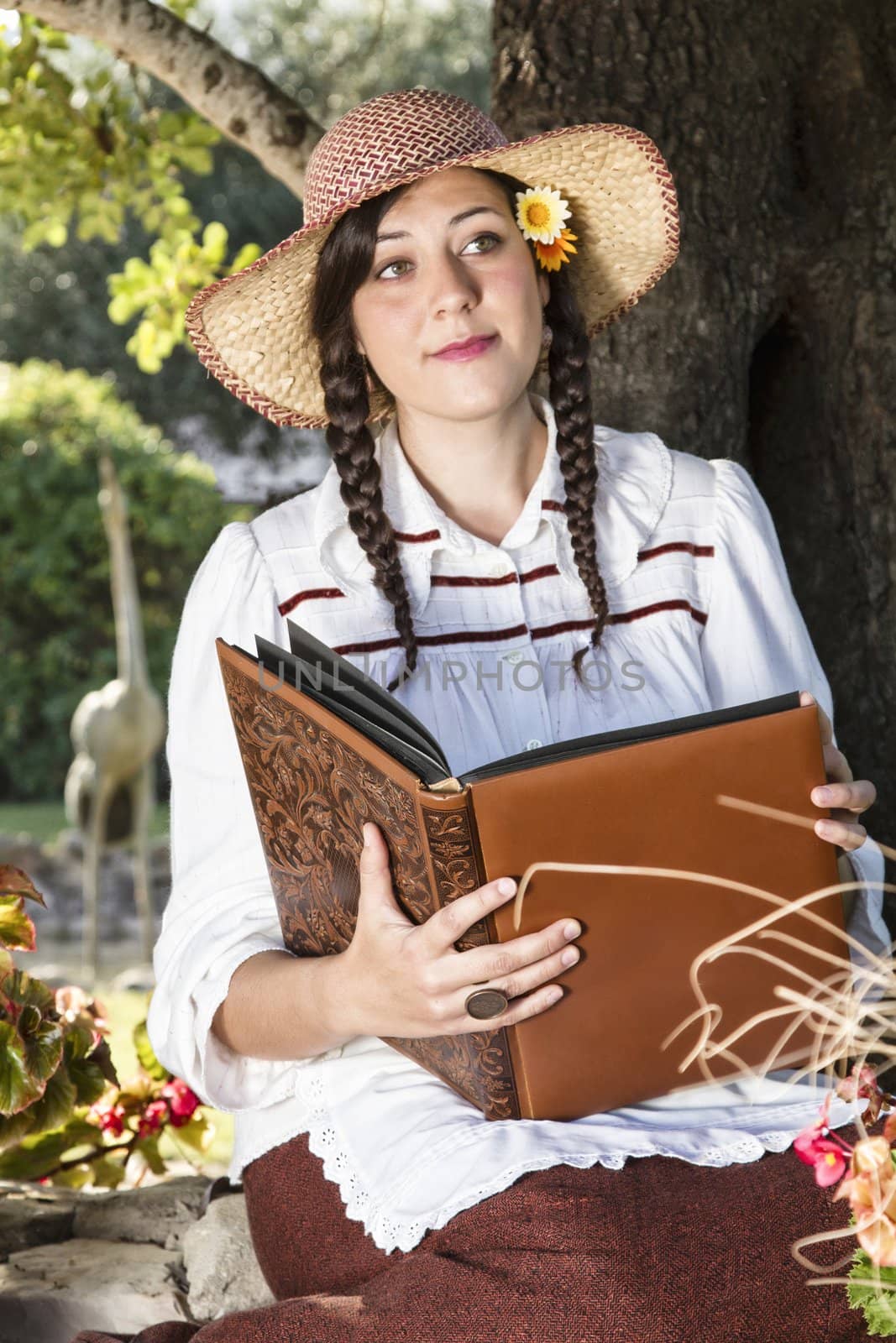 View of a beautiful girl in a classic dress reading a story book.