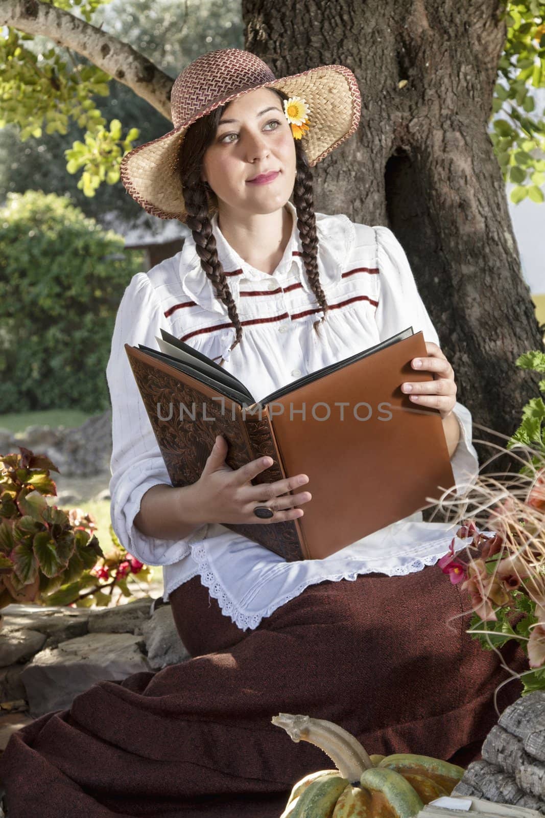 View of a beautiful girl in a classic dress reading a story book.