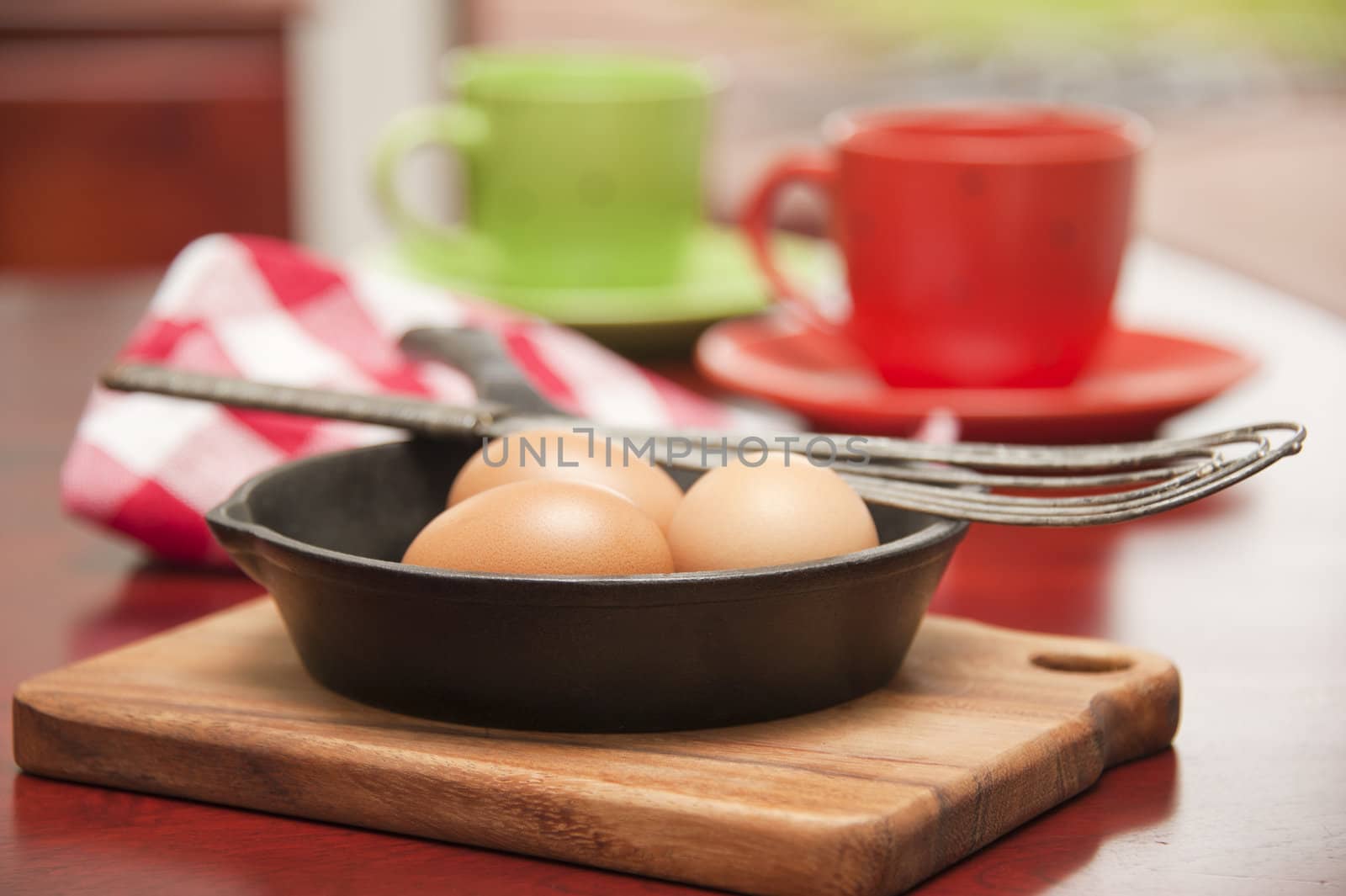 Three whole eggs in a skillet to be prepared for breakfast.