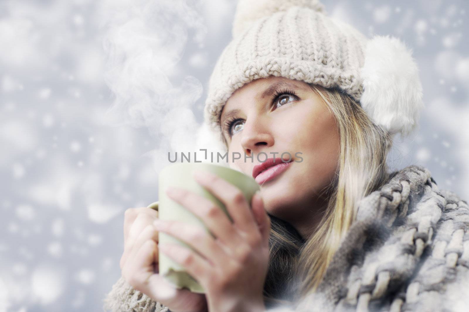 Young woman wearing winter clothes having a hot drink 