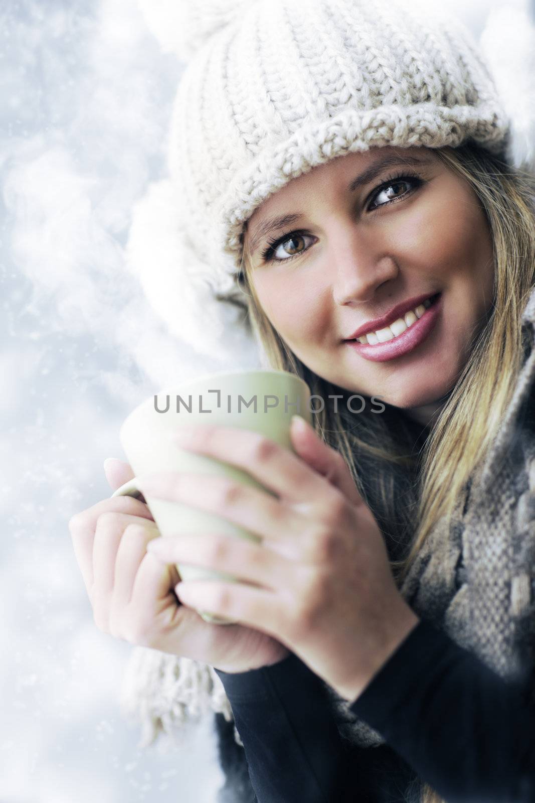 Young woman wearing winter clothes having a hot drink 