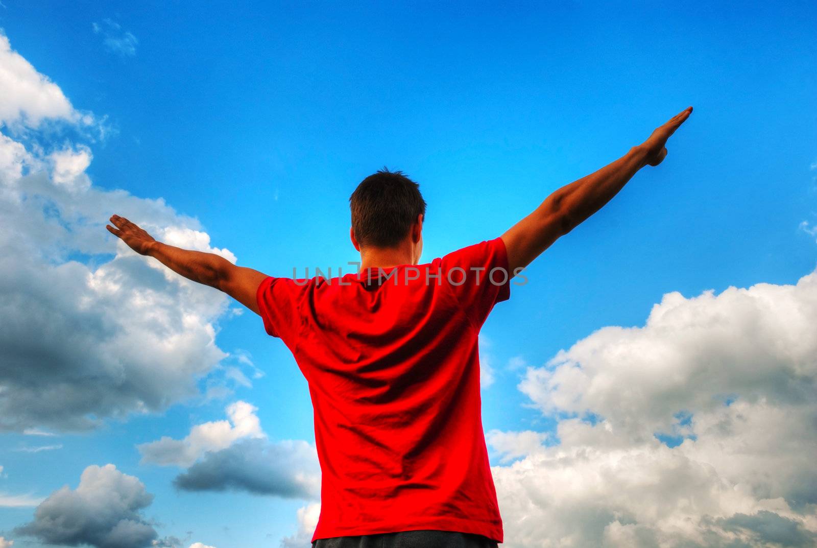 Young man staying with raised hands by AndreyKr