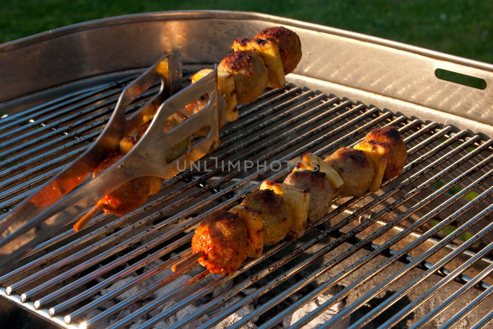 Cooking a few Meat Brochettes on a Barbecue outside in the garden