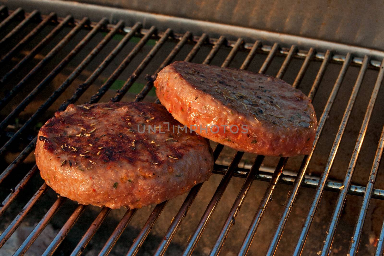 Cooking a few Hamburgers on a Barbecue outside in the garden