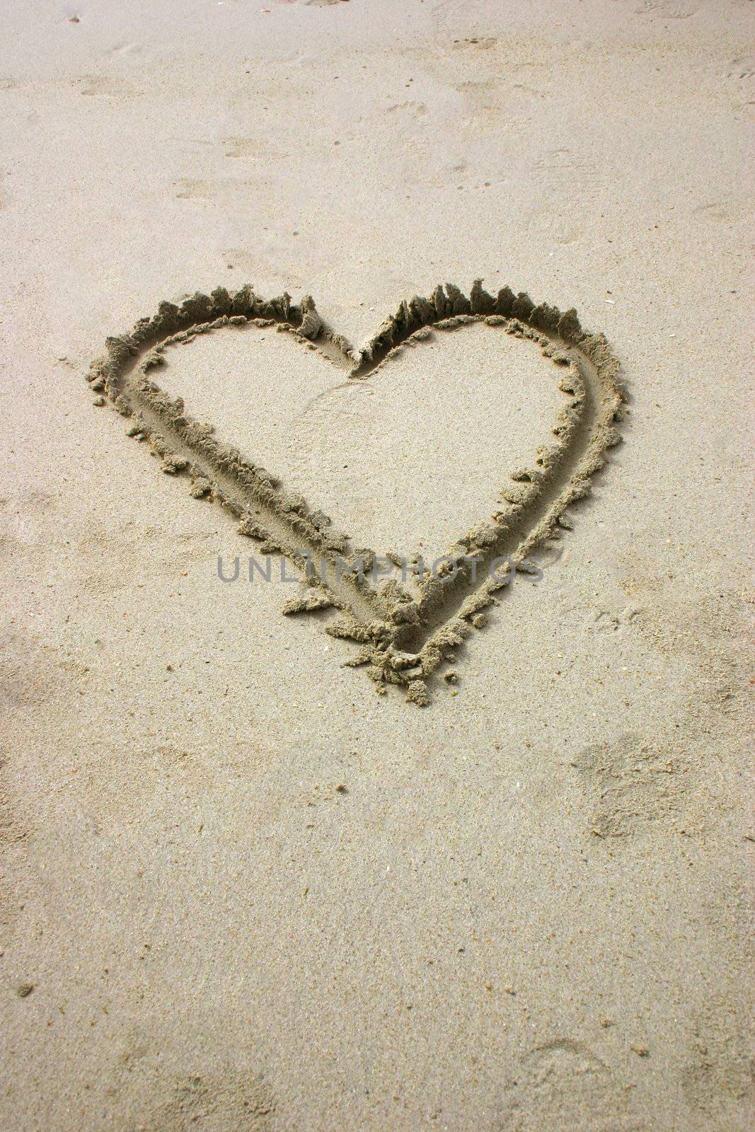Heart written by hand in sand on the beach